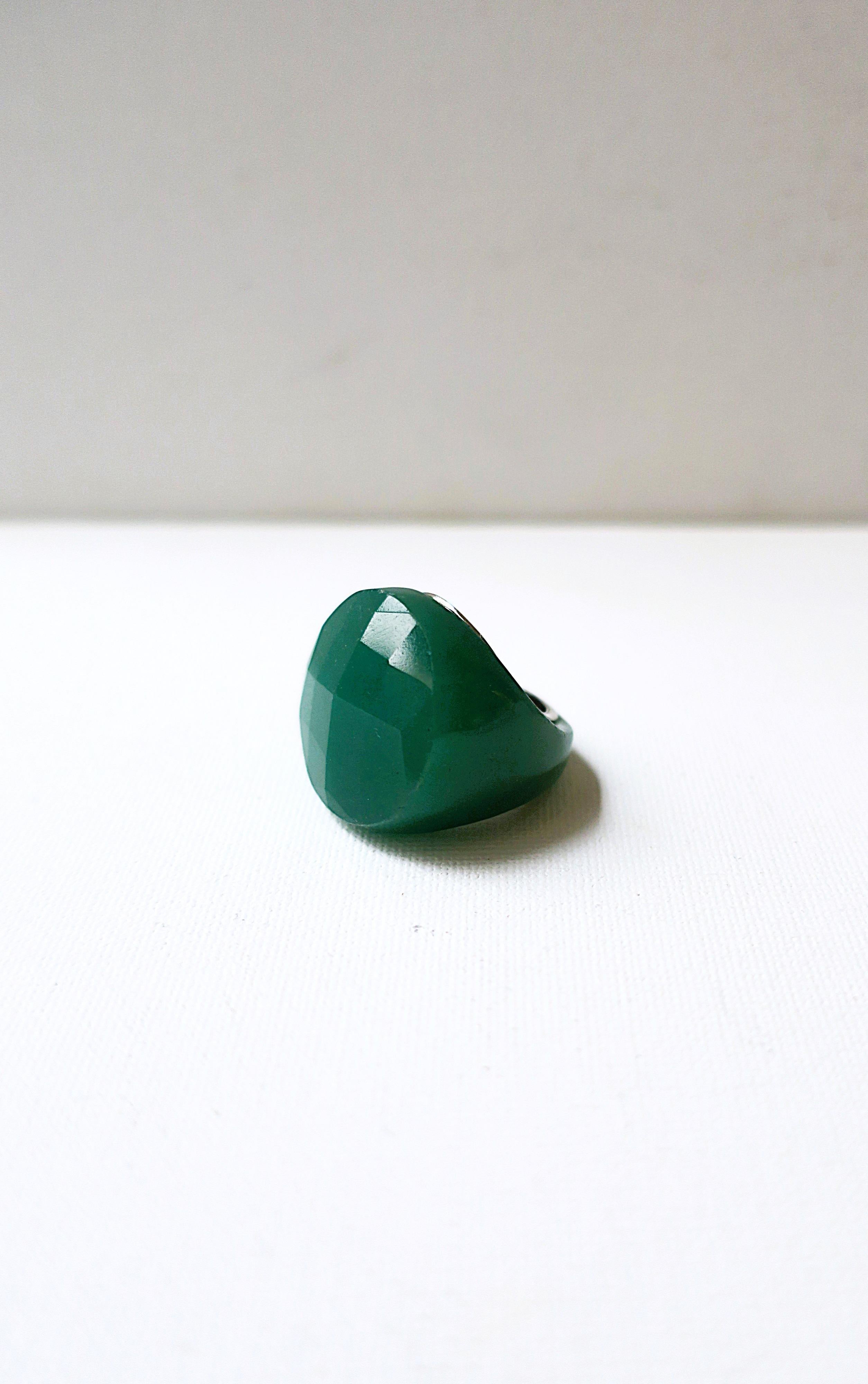 A relatively large green stone and sterling silver ring with facetted cut top. Ring is made from one piece of stone with a sterling silver inside band area. Diameter top measures 1