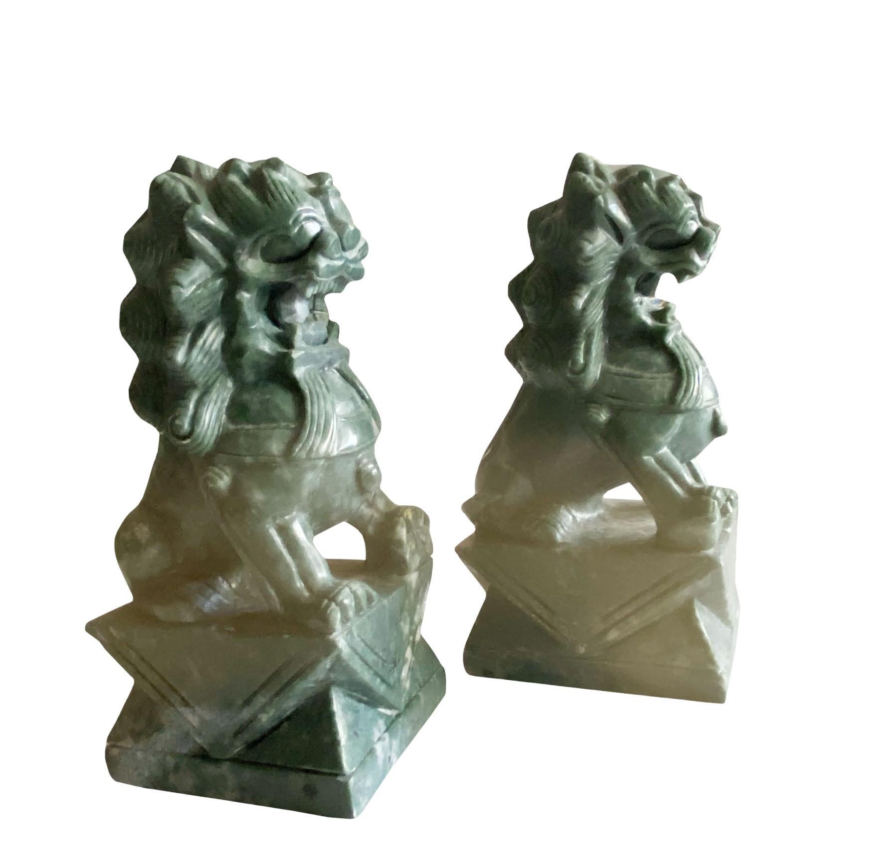 A pair of Chinese green stone foo dogs. Early 20th century, China.