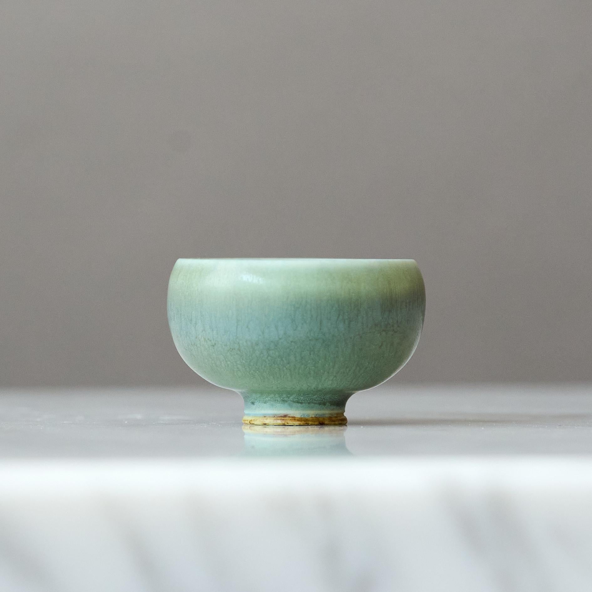Un magnifique bol miniature en grès avec une étonnante glaçure en fourrure de lièvre verte.
Fabriqué par le maître lanceur Berndt Friberg, dans le studio de l'artiste à Gustavsberg, en Suède, dans les années 1960.

Excellent état. 
Signature incisée