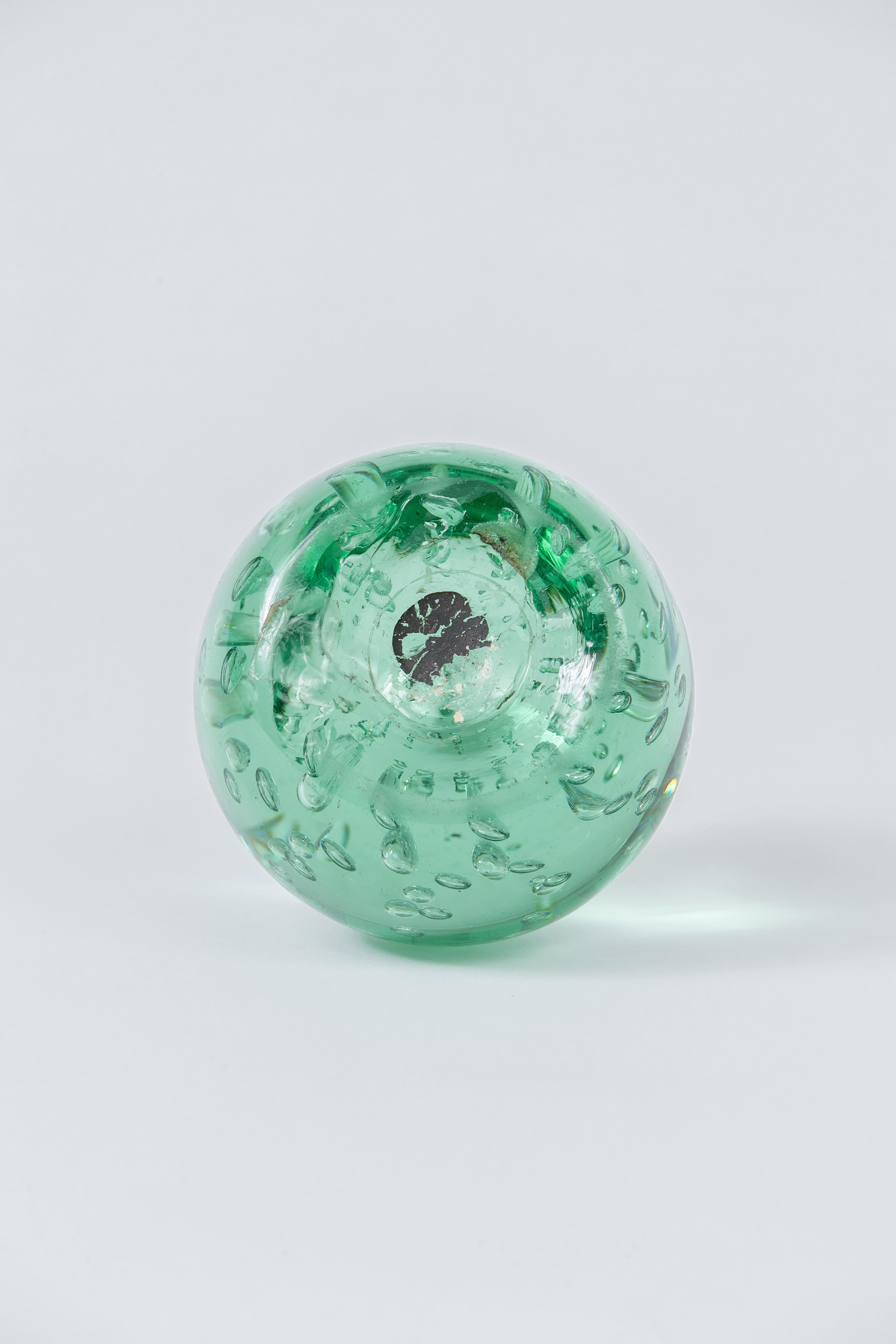 A heavy green sulfur glass paperweight, most likely from Murano.