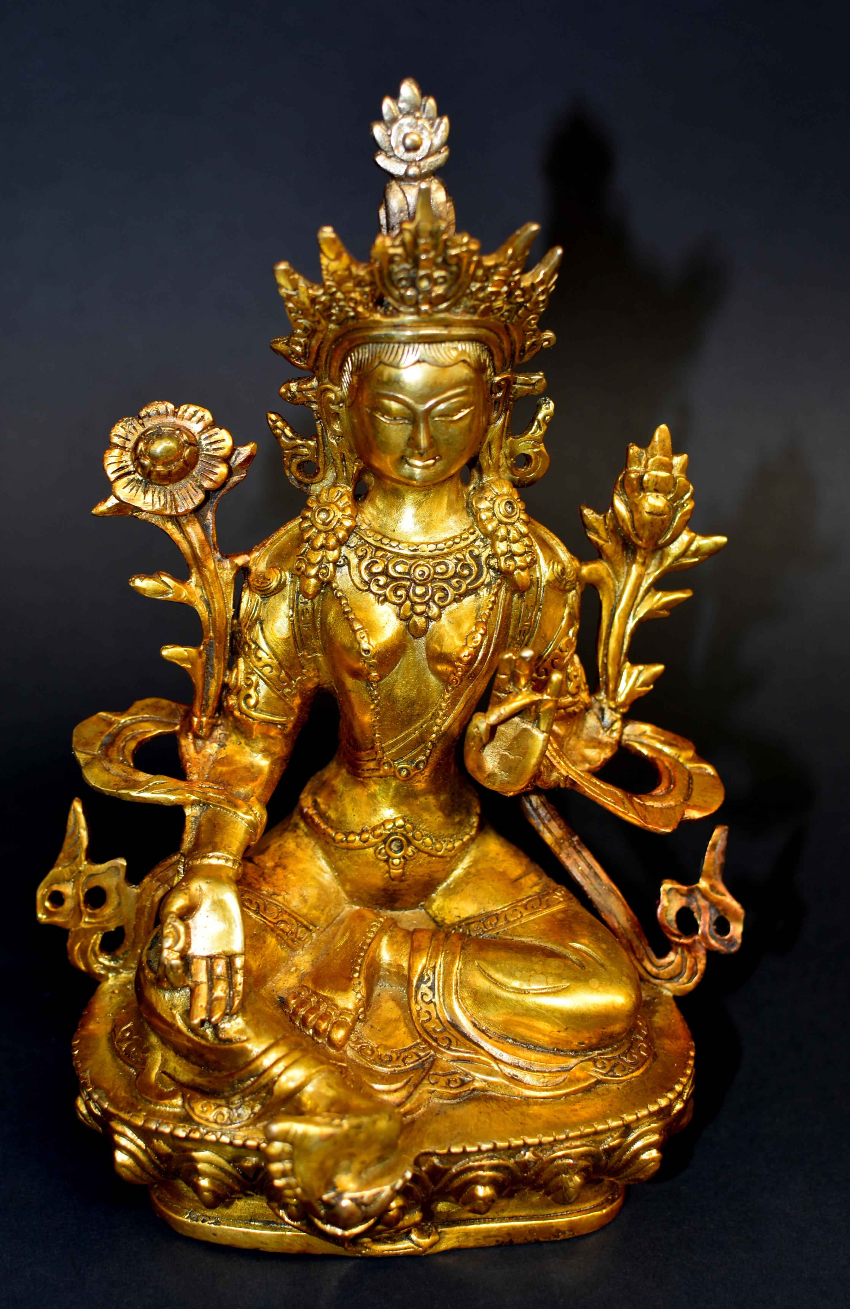 A stunning gilt bronze statue of Avalokiteshvara, the Great Compassion Green Tara. Seated in lalitasana with the right foot supported on a lotus stem that projects from the front of the double-lotus base. The hands are held in vitarkamudra with the