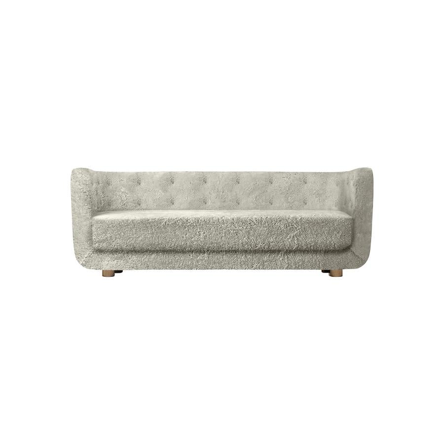 Green tea sheepskin and natural oak Vilhelm Sofa by Lassen.
Dimensions: W 217 x D 88 x H 80 cm. 
Materials: sheepskin, oak.

Vilhelm is a beautiful padded three-seater sofa designed by Flemming Lassen in 1935. A sofa must be able to function in