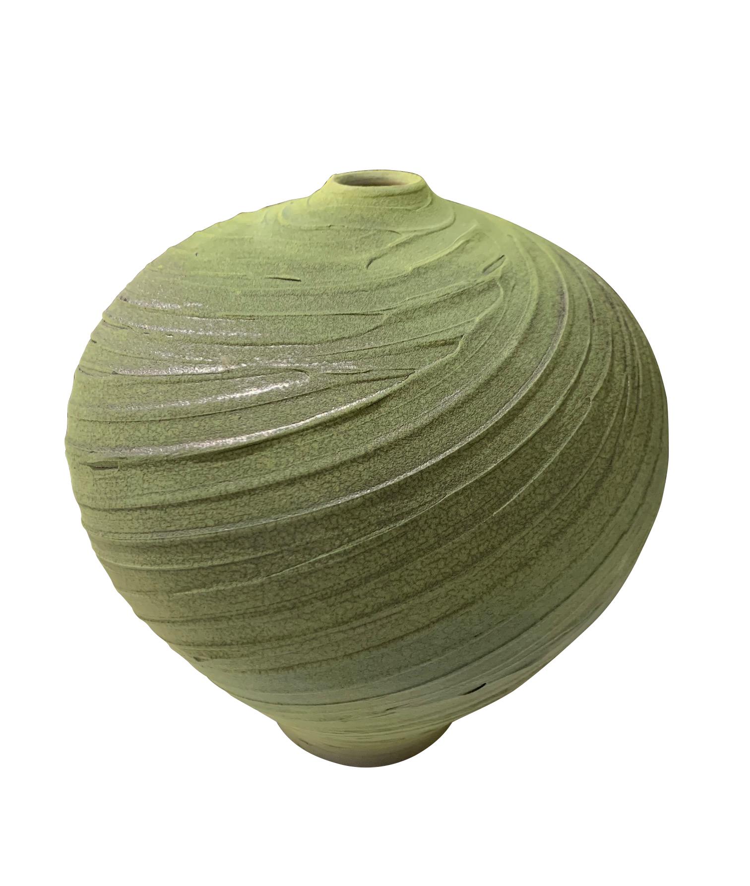 Contemporary textured ceramic earthenware vase.
Green body carved in a spiral pattern.
The vase design has an ancient feel.
Hand made one of a kind.
Part of a collection of earthenware vases.