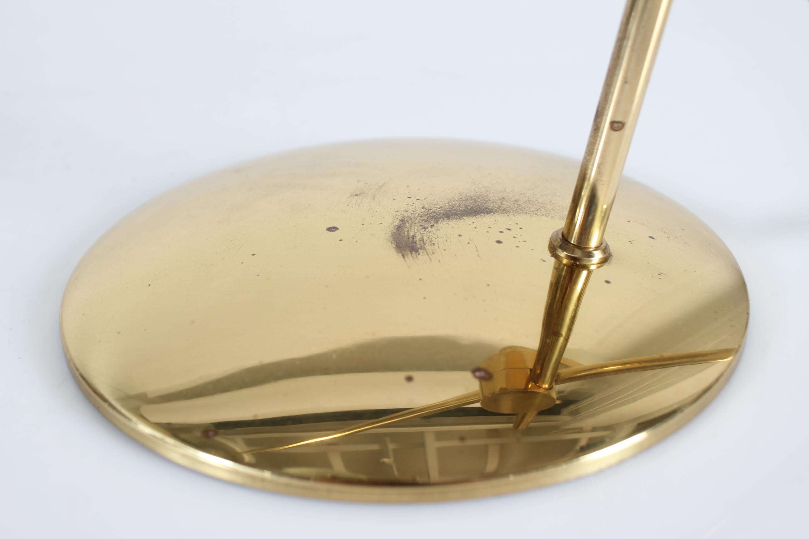 Original vintage desk lamp designed by Th. Valentiner manufactured in Denmark by Poul Dinesen in the 1960s.

The frame and base is made of brass with lacquer and the obliquely cut shade  painted with dark green lacquer on the outside and white on