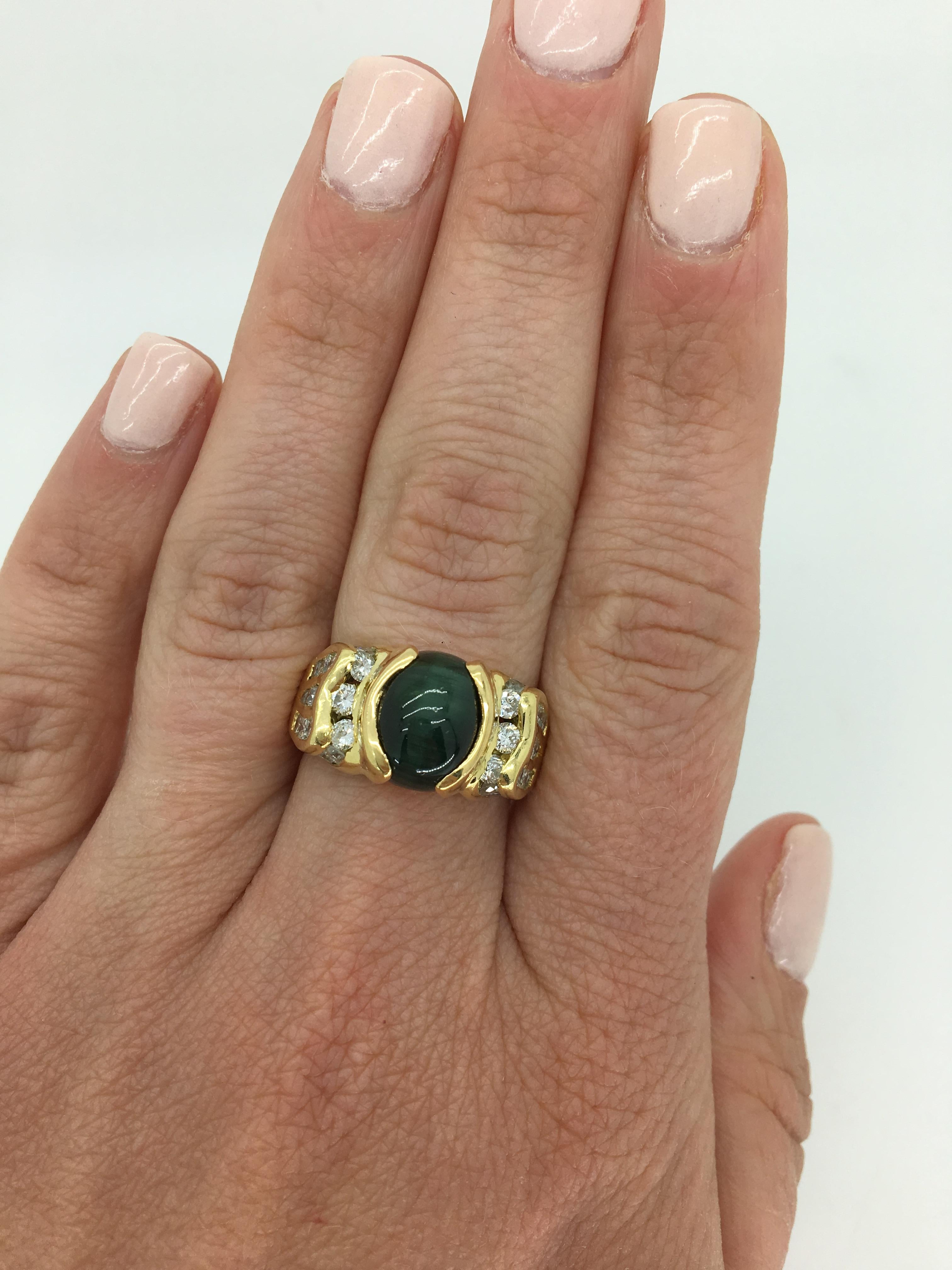 Cabochon cut Tigers Eye cocktail ring with approximately 2.00 carats of accenting diamonds crafted in 18k yellow gold.

Gemstone: Green Tigers Eye & Diamond
Gemstone Carat Weight: Approximately 11x8mm Oval Cabochon Cut
Diamond Carat Weight: