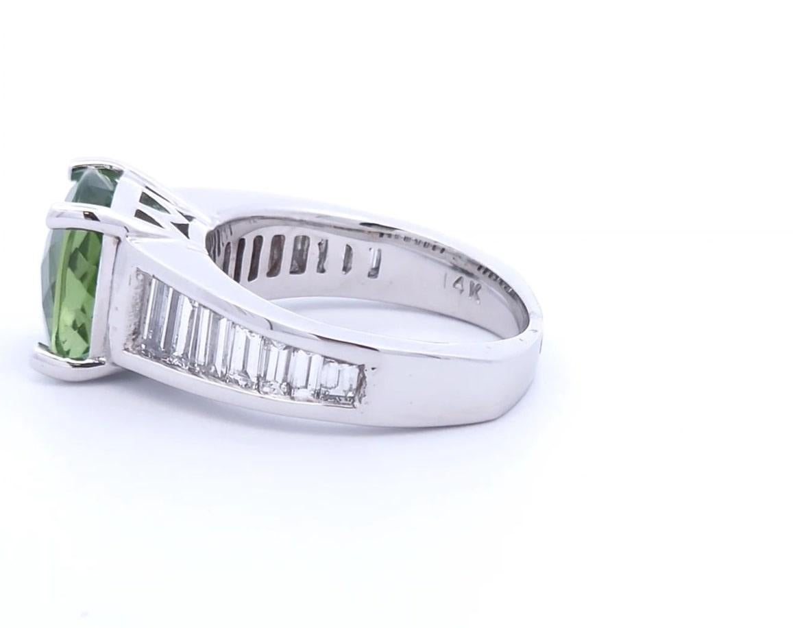Le luxe au juste prix

Cette bague unique a un poids total de 5.89 carats. La pierre centrale est une tourmaline verte taillée en coussin pesant 4,41 carats. La tourmaline verte est entourée de 1,48 carats de diamants de taille baguette sertis en or