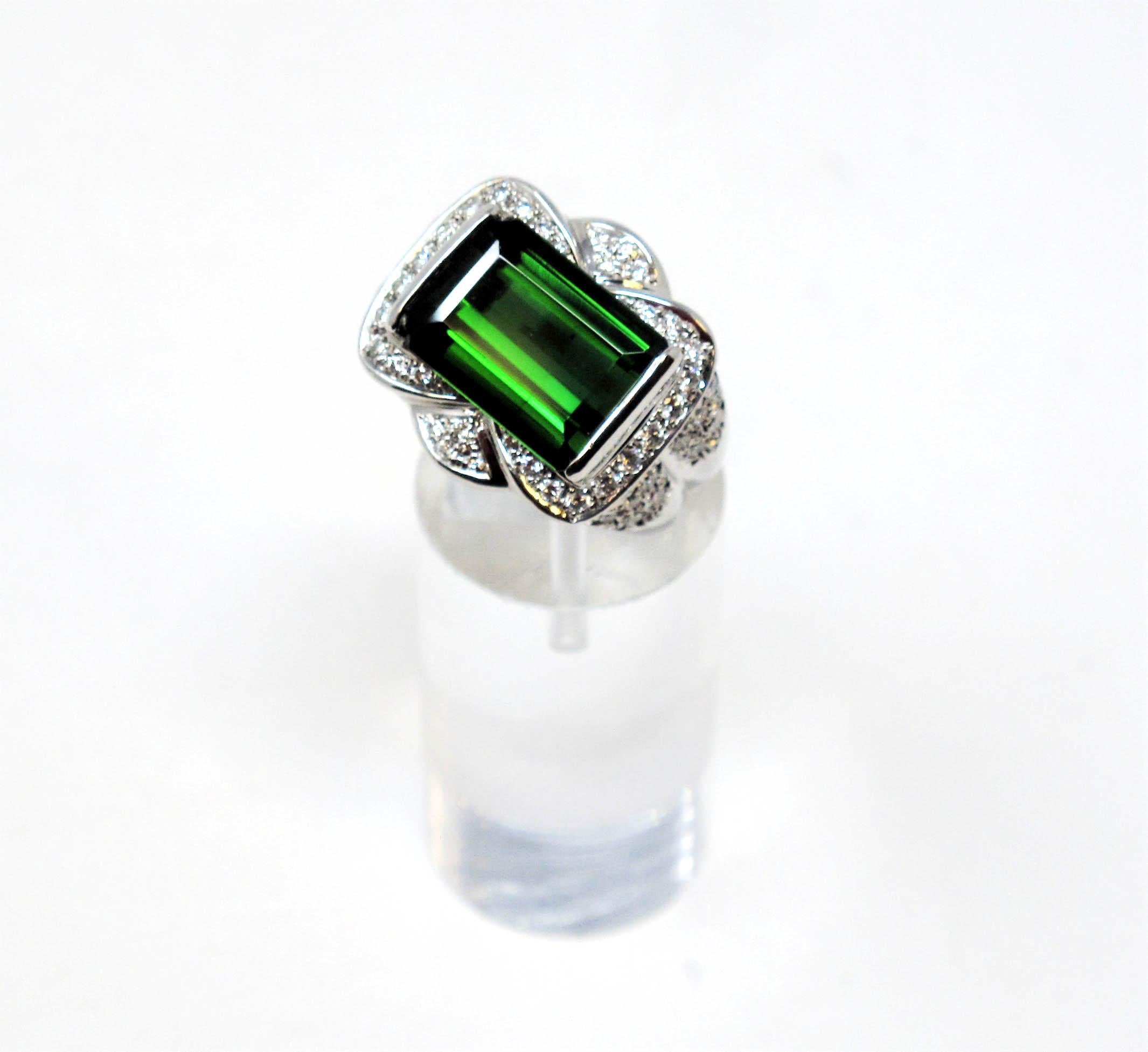 Ring size: 6

Bold, beautiful green tourmaline and diamond cocktail ring. The vibrant green stone against the bright white diamonds really catches the viewers eye. It is substantial in both size and sparkle, making this ring a true treasure. 

The