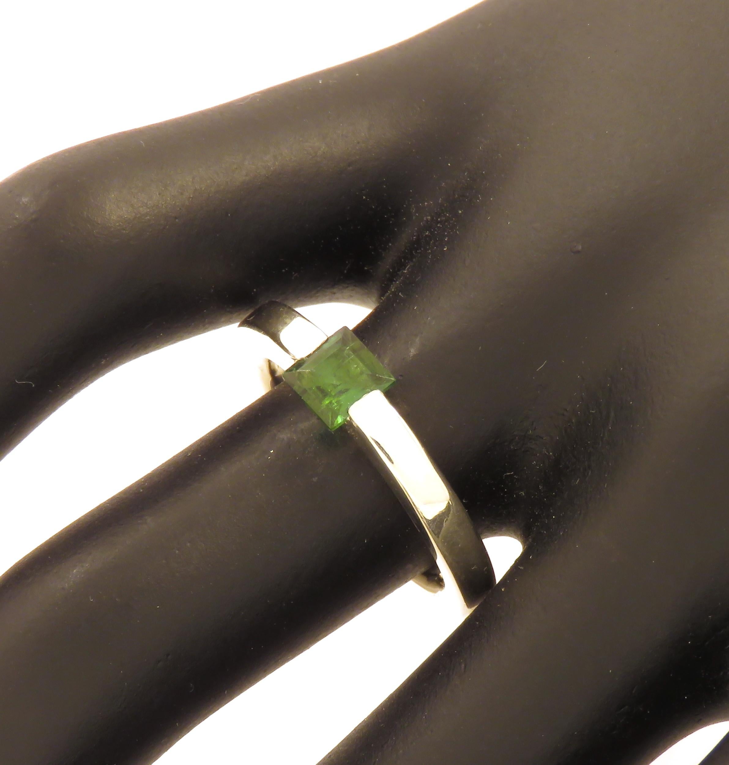 Very stylish modern band ring crafted in 9k white gold featuring at the centre a square cut natural green tourmaline. The dimension of the gemstone is 5 x 5 millimeters / 0.196 x 0.196 inches. This ring is also available with square cut gold topaz