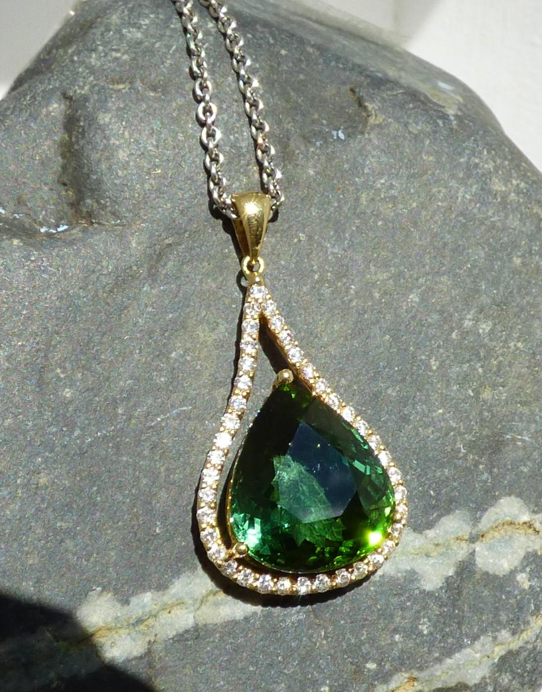 An exquisite 17X15mm pear shaped green Tourmaline (17.82ct.) is set with 40 Diamonds (.81ct.) in a Lapis Jewellers handmade 18K yellow gold pendant. The pendant is hallmarked by the Dublin Assay Office.  This pendant drops from an 18
