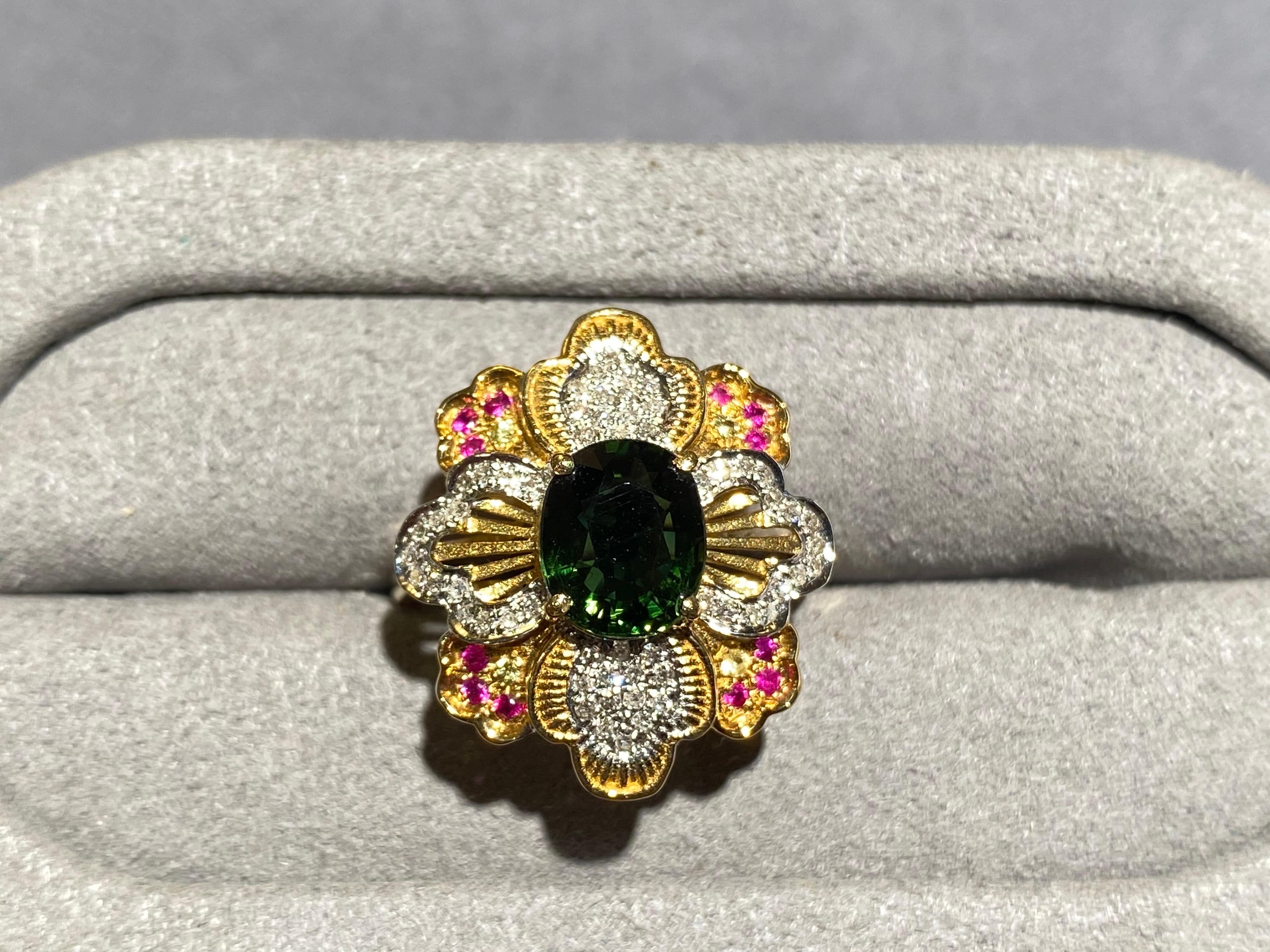 A green tourmaline and diamond ring in 18k yellow gold. The green tourmaline is set in the middle of a 8 petals flower motif. On the first layer there are 4 petals, each of them is set with micro diamond pave. The petals in the bottom layer is
