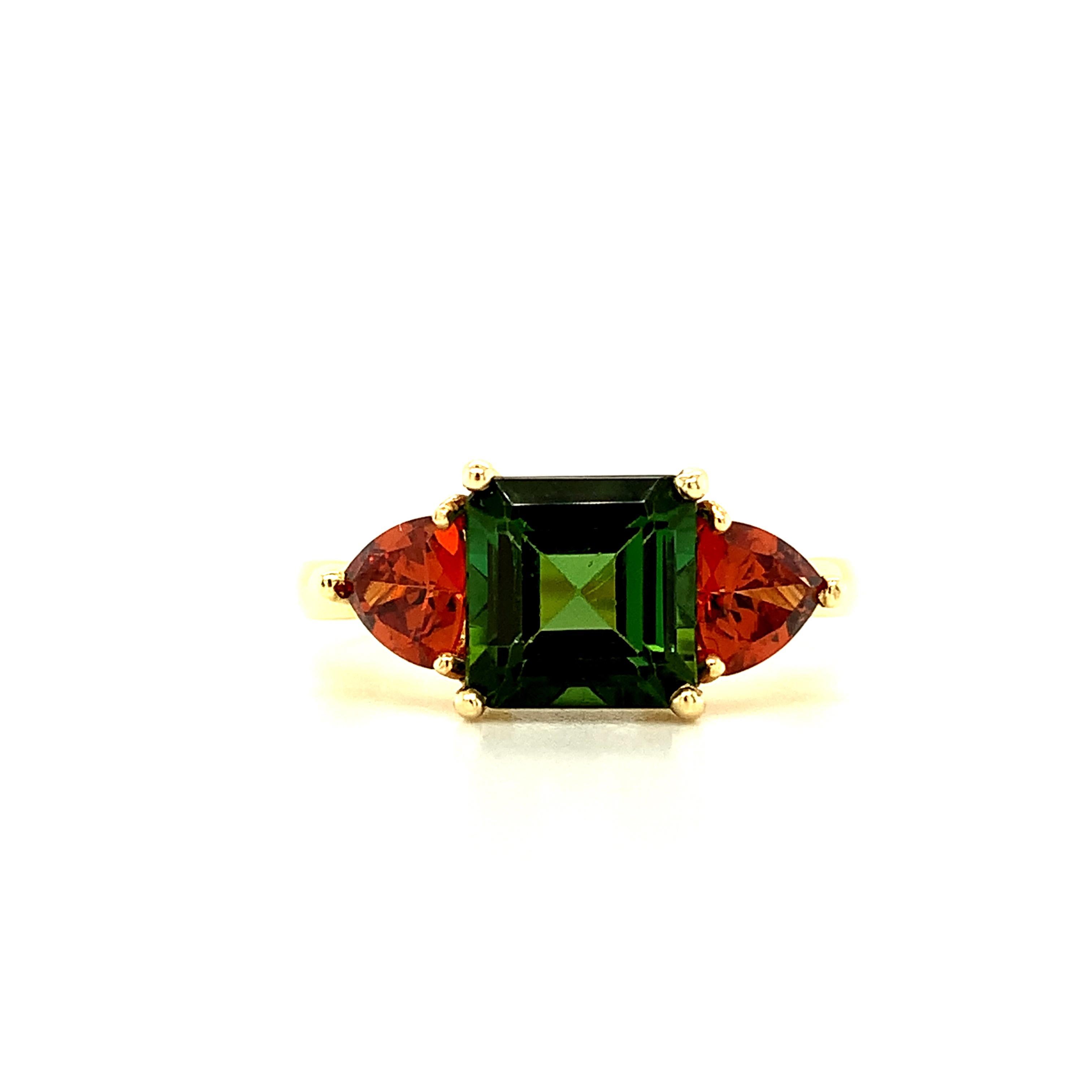 This pretty ring features a rich green tourmaline and orange garnets in a fresh, nature-inspired color combination! The 2.22 carat center tourmaline is emerald-cut and a vibrant shade of luscious pine green. Sparkling orange spessartite garnet
