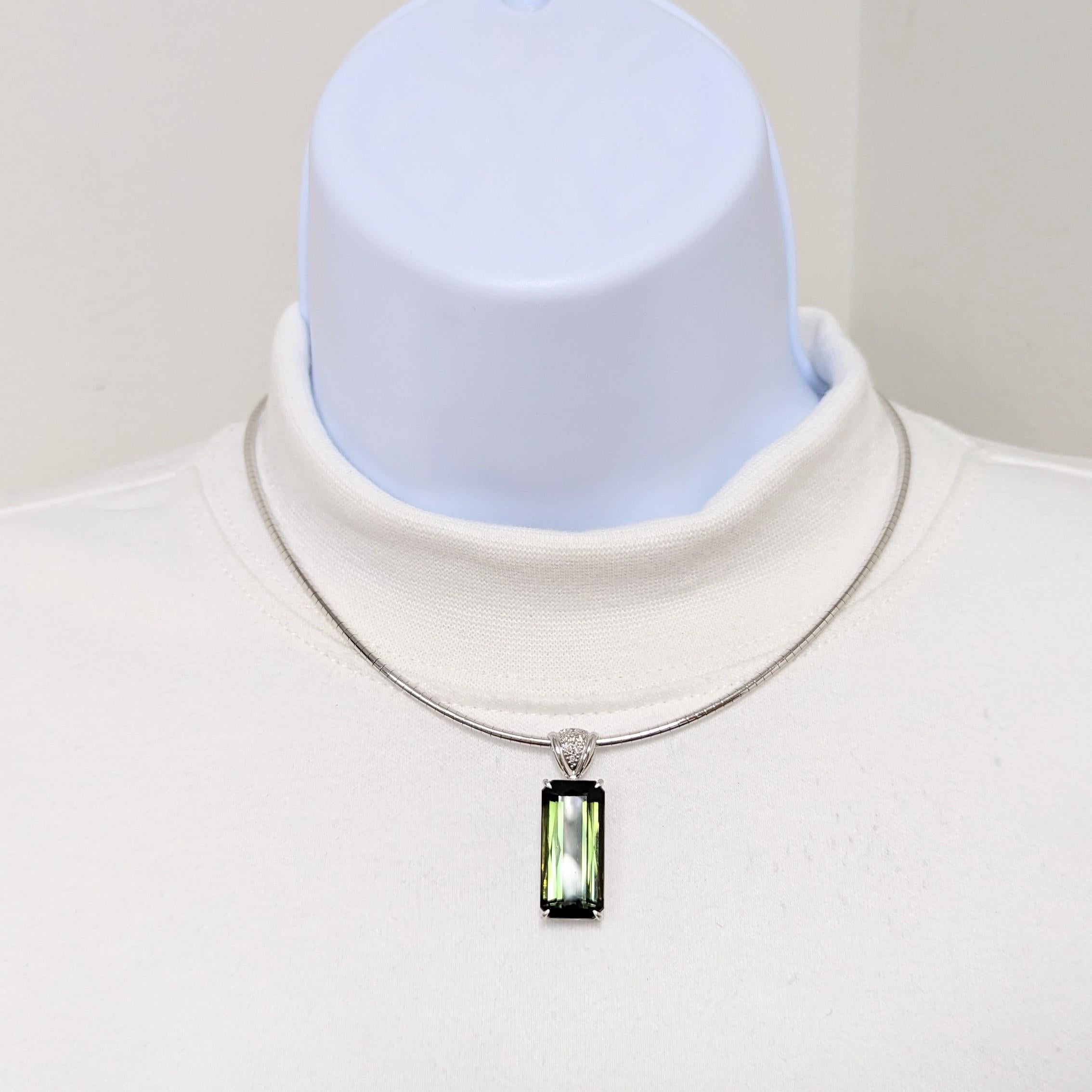Beautiful 24.38 ct. green tourmaline emerald cut with 0.06 ct. good quality white diamond rounds.  Handmade in 18k white gold with an omega chain.