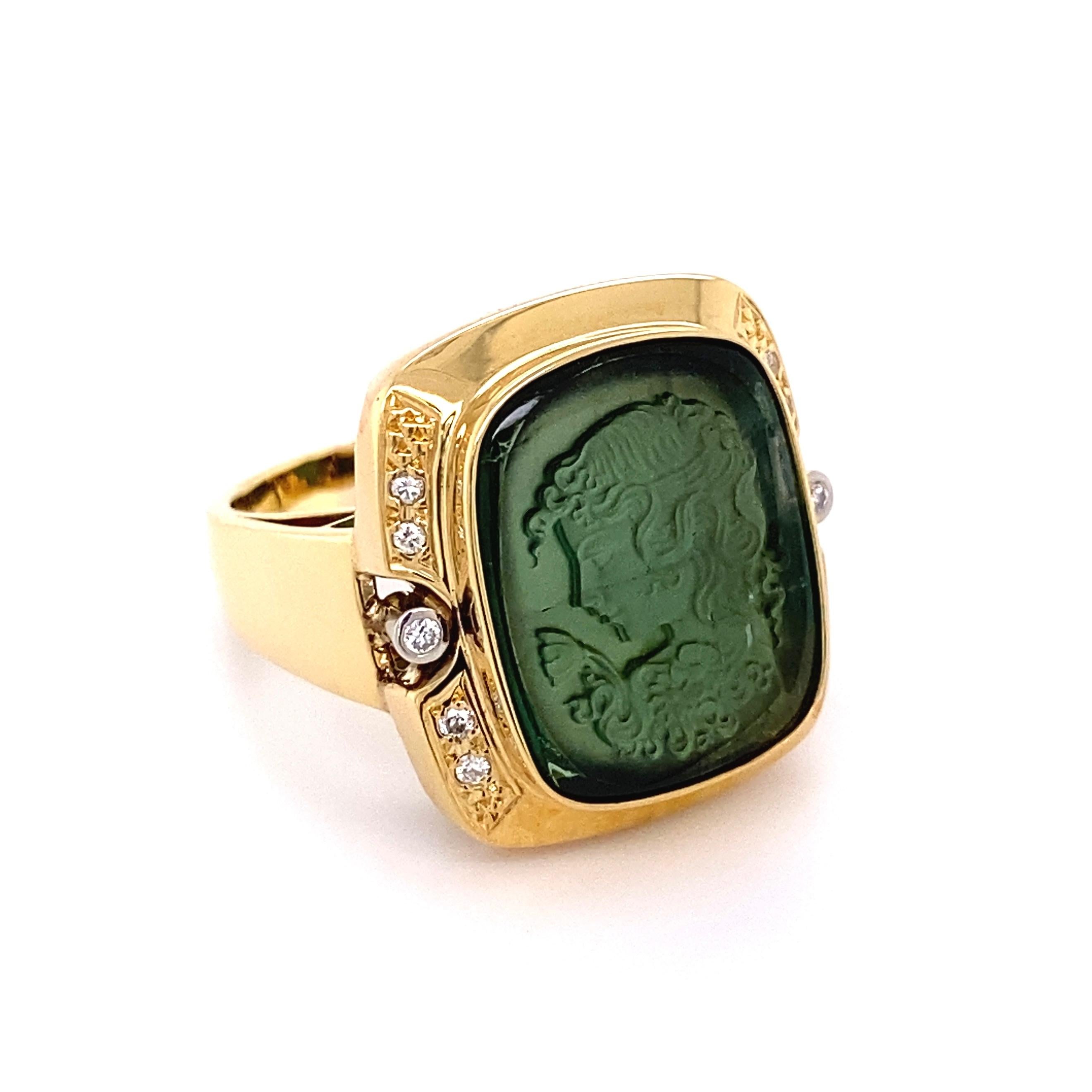 Simply Beautiful and finely detailed Tourmaline, subtly Hand carved Lady's face, securely nestled in center and enhanced either side with Diamonds, weighing approx. 0.11 total carat weight. Diamonds Bezel set in Platinum. Hand crafted in 18 Karat