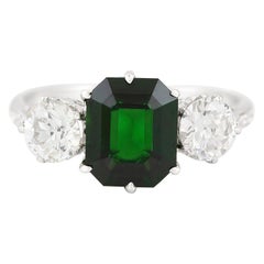 Verlobungsring mit grünem Turmalin in der Mitte und zwei Diamanten