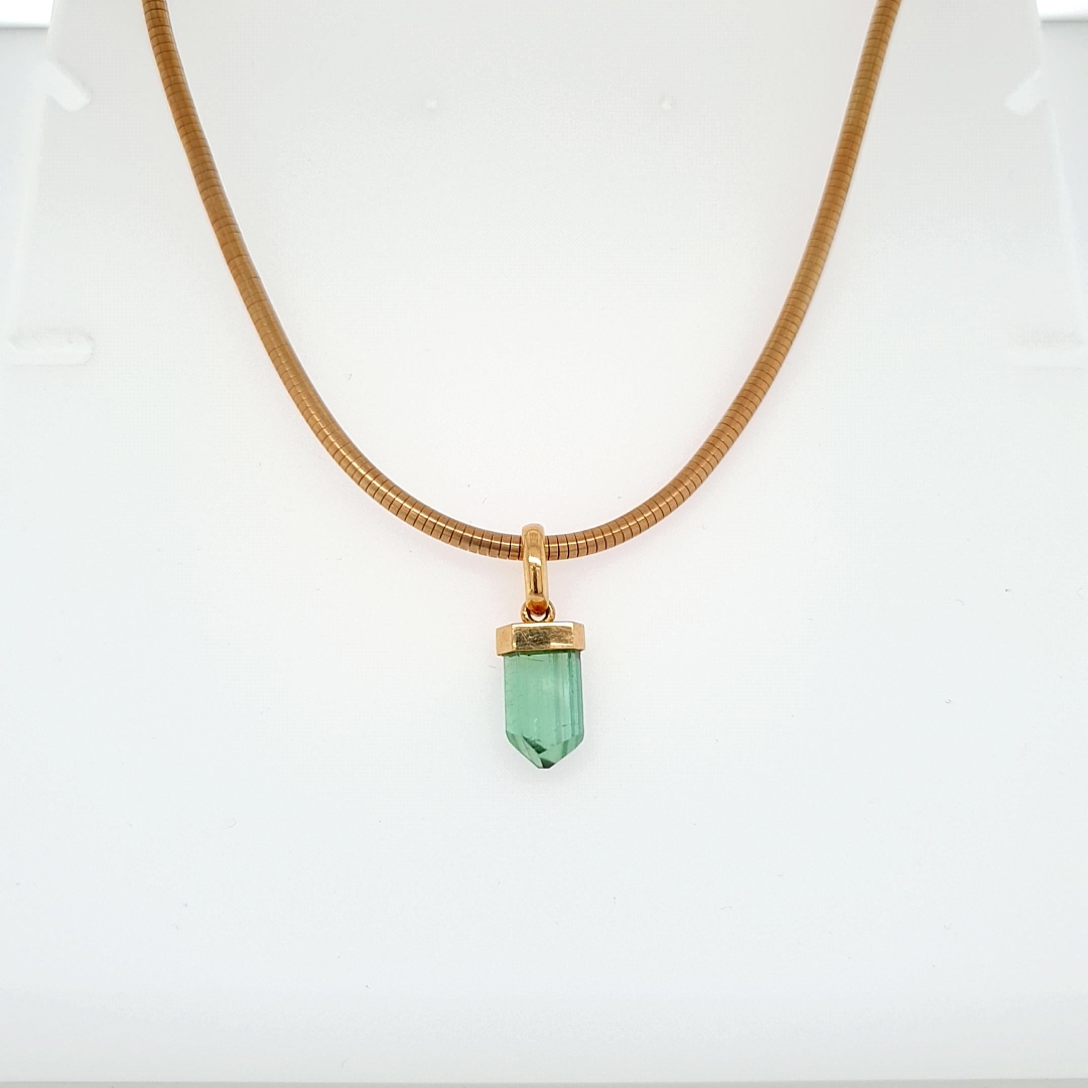 This Natural Green Tourmaline Crystal Beaded Pendant with 18 Carat yellow Gold Snake Chain is done in in German quality. The bayonet clasp is easy to handle and very secure. The crystals surface is completly natural and not repolished.

Tourmaline