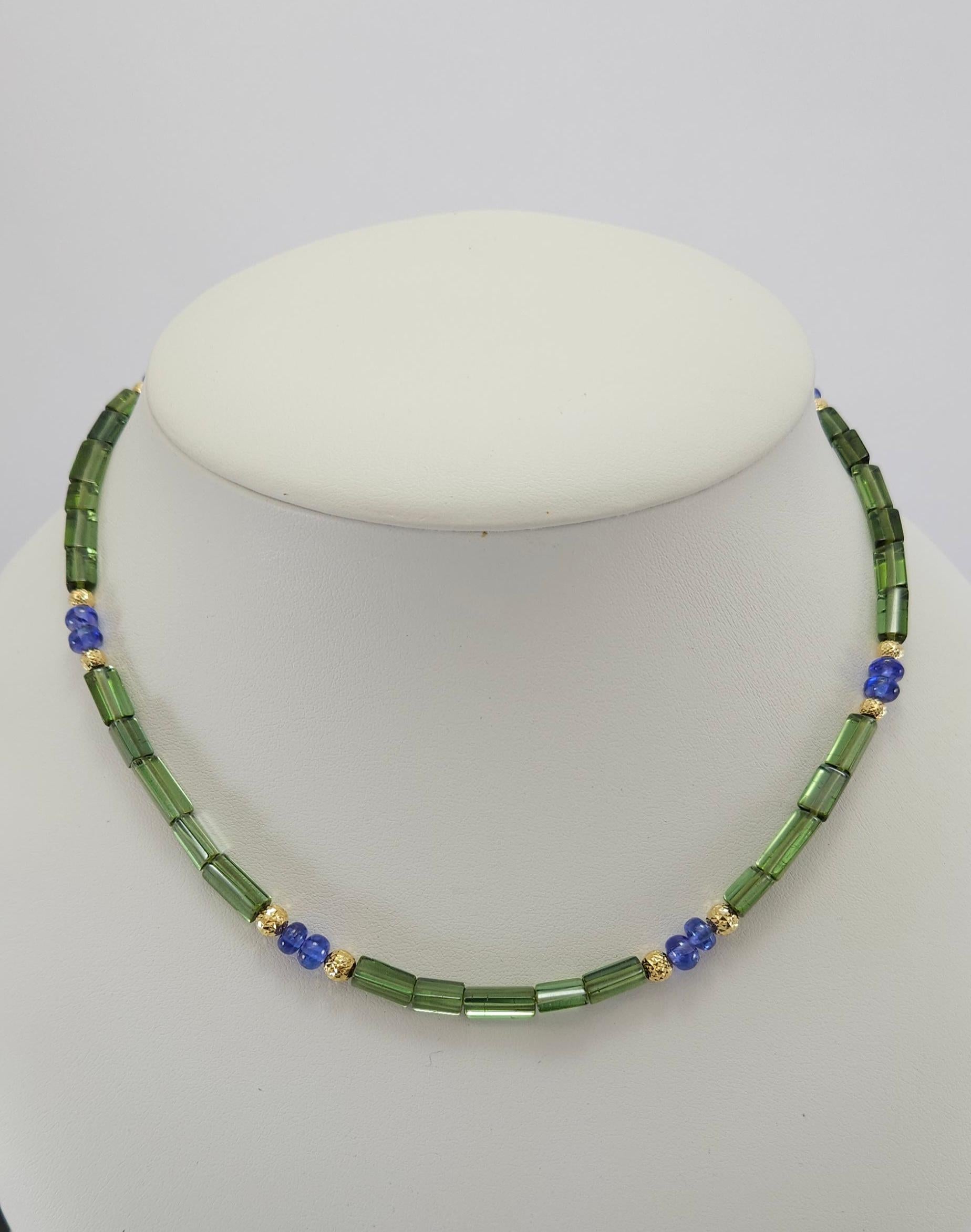 This Natural Green Tourmaline Crystal & Tanzanite Rondel Necklace with 18 Carat yellow Gold is handcut and made in German quality.
The screw clasp is easy to handle and very secure. The triangular shape was taken from the natural crystals of