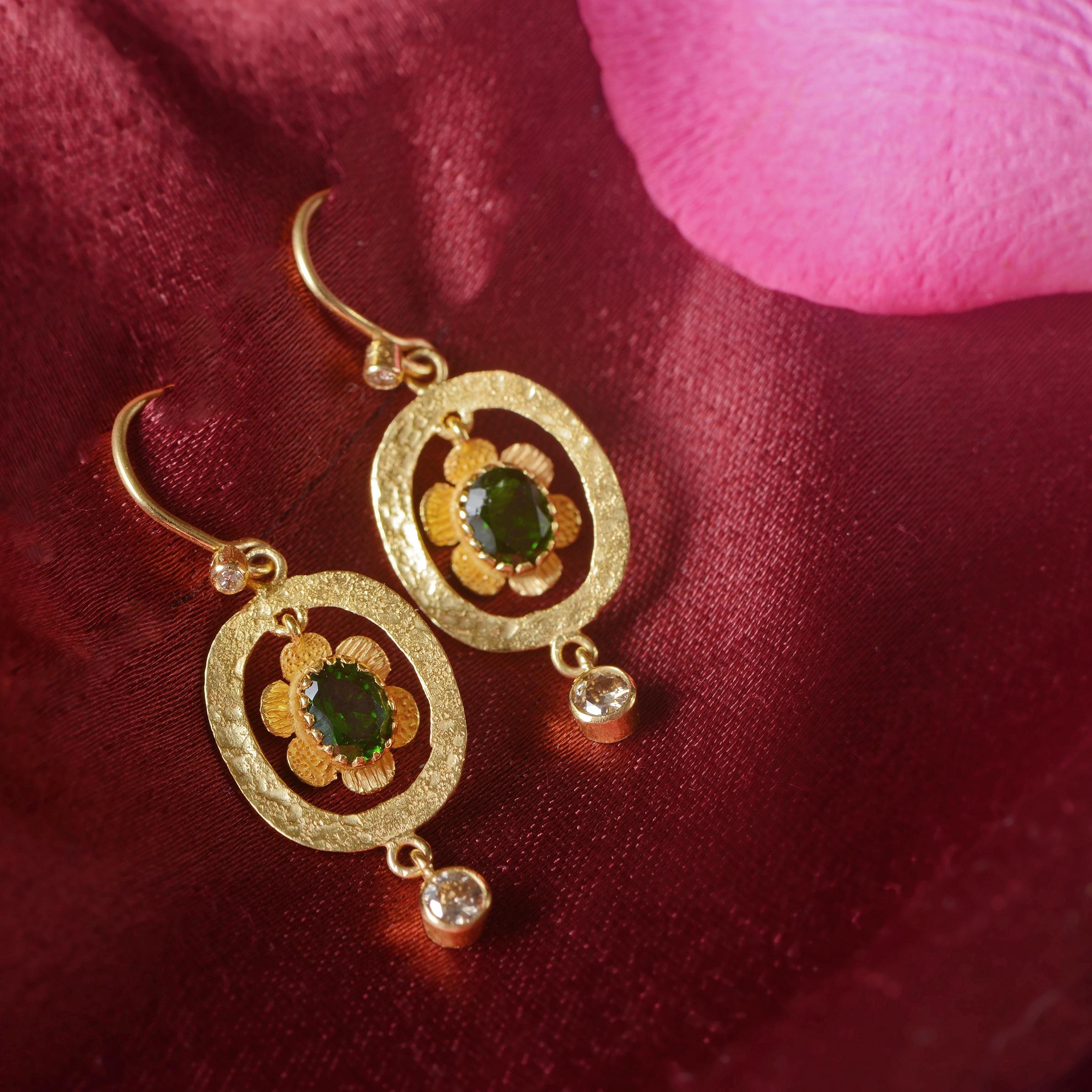 

These beautiful one-of-a-kind tourmaline and diamond gold dangle earrings have been handmade in our workshops. Made in 18kt lightly textured gold, they feature green tourmaline drops and at the top and bottom of the earrings are full cut