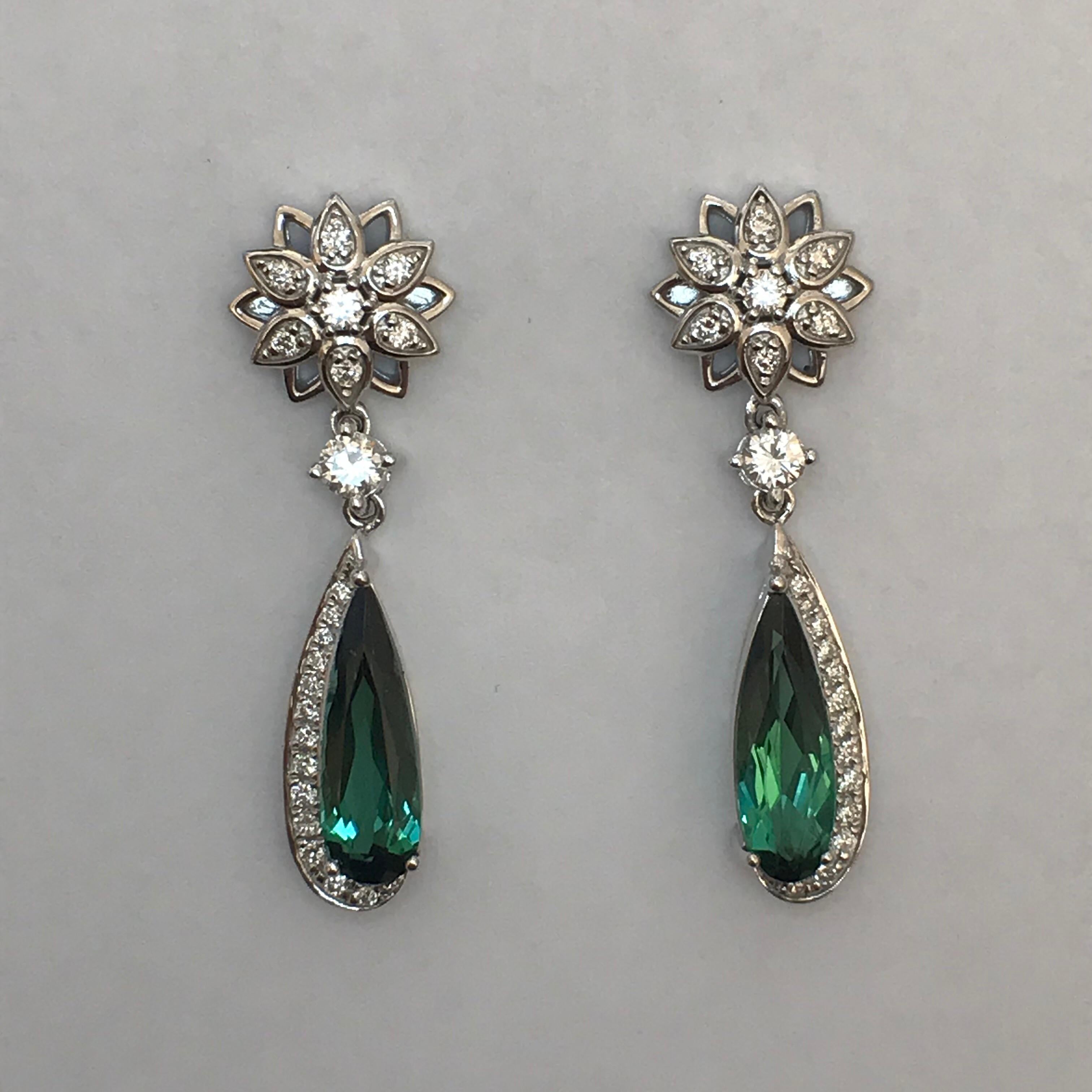 Star-like flowers of alternating diamond and open petals suspend elongated pear-shaped green tourmalines cradled in hook-shaped frames. A diamond is set between the two motifs for additional length and movement.

Elongated Pear-Shaped Green
