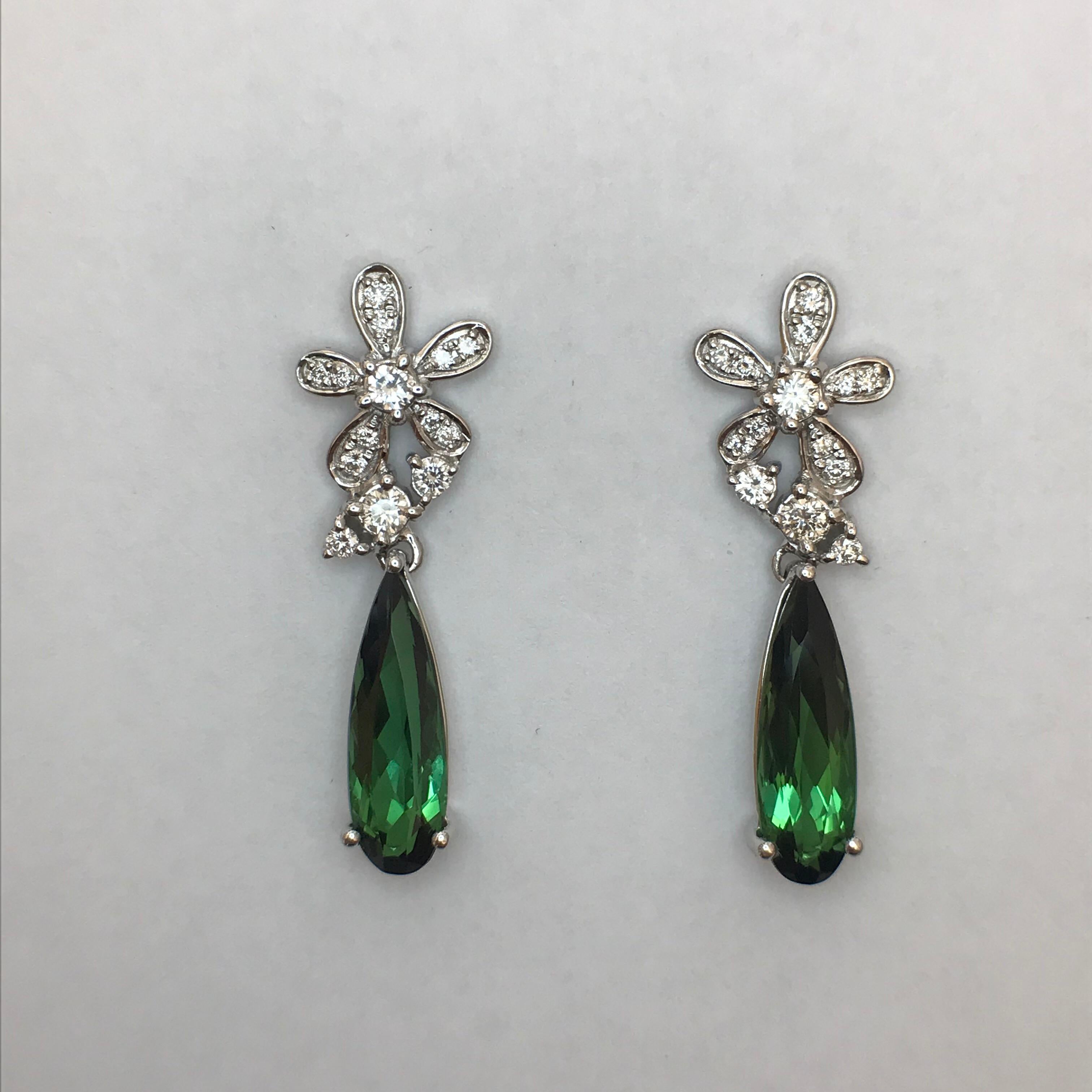 Playful flower and bud motifs composed of diamonds suspend elongated green tourmaline drops in these earrings that can be worn day or night.

Elongated Pear-Shaped Green Tourmalines: 3.47cts. Total Weight
Round Brilliant-Cut Diamonds: 0.51ct. Total