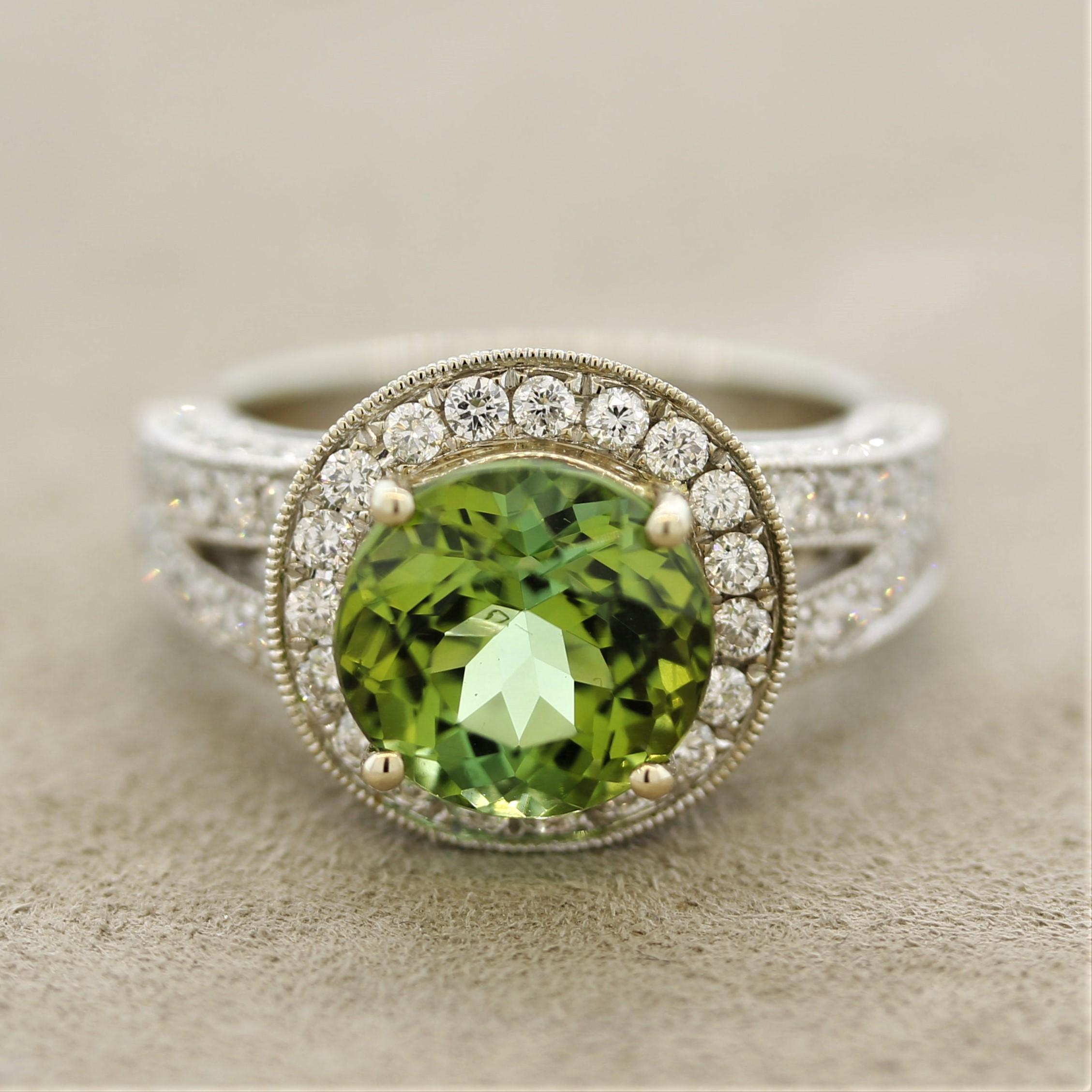 A gem 4.46 carat vivid green colored tourmaline, with subtle hints of yellow and blue, take center stage. It is accented by 1.62 carats of round brilliant-cut diamonds set around the tourmaline and down the shoulders of the ring. Made in 18k white