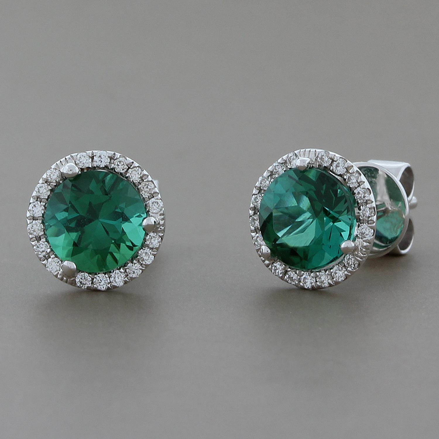 Green with envy! A perfect everyday stud earring featuring 1.88 carats of round green tourmaline earrings haloed by 0.16 carats of round white VS quality diamonds. Set in 18K white gold.

Approximately, 8 mm diameter

