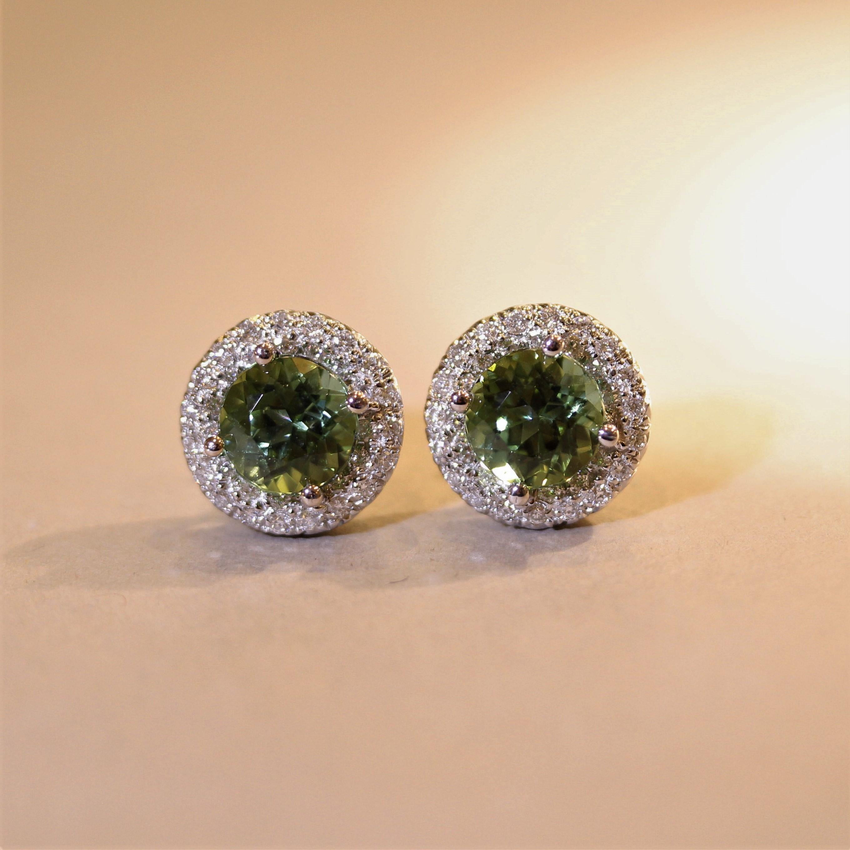 A simple yet extra fine pair of stud earrings! They feature gem lime-green colored tourmalines which weigh a total of 4.12 carats. Their color and brilliance are extra fine. It is accented by halos of round brilliant-cut diamonds which total 0.75