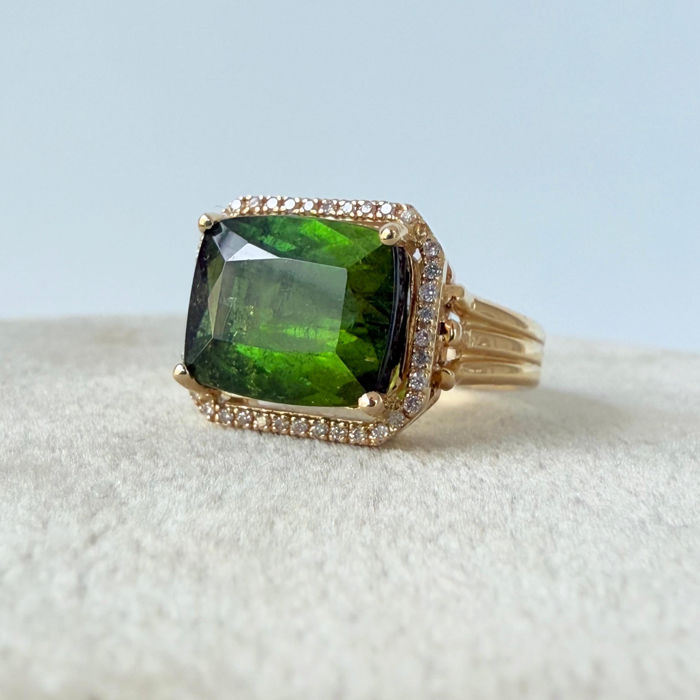 Stunning One of A Kind Ring by Marina J.

This ring features an emerald cut Green Tourmaline which radiates a magnificent Green Hue. The Tourmaline is bordered by a Diamond Halo. The decorative solid 14k Yellow Gold shank perfectly contrasts the