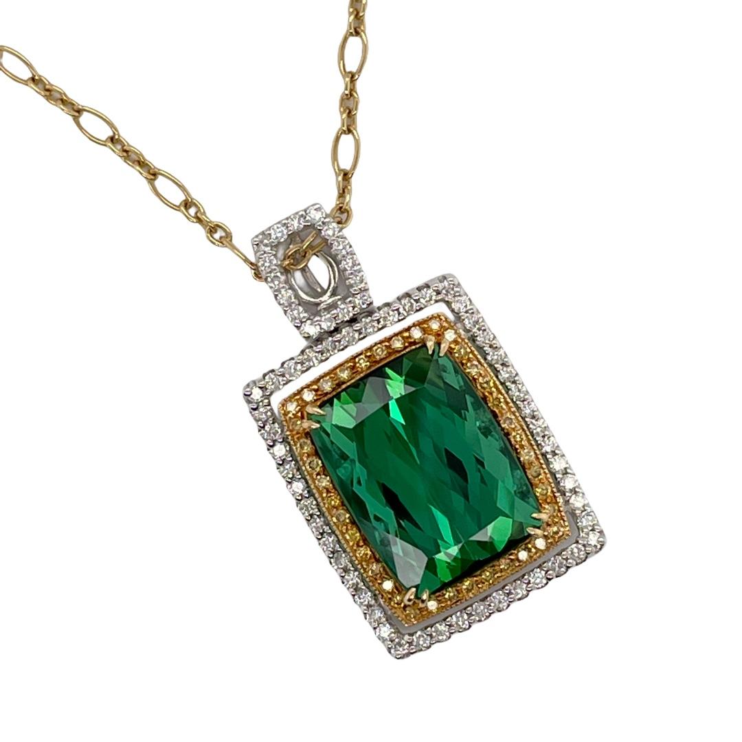 Green Tourmaline & Diamond Pendant in 18K White & Yellow Gold. Pendant contains 1 center checkerboard faceted cushion cut green tourmaline, 7.45ct and a double halo of white & yellow diamonds surrounding center stone, 1.00tcw. White diamonds are G