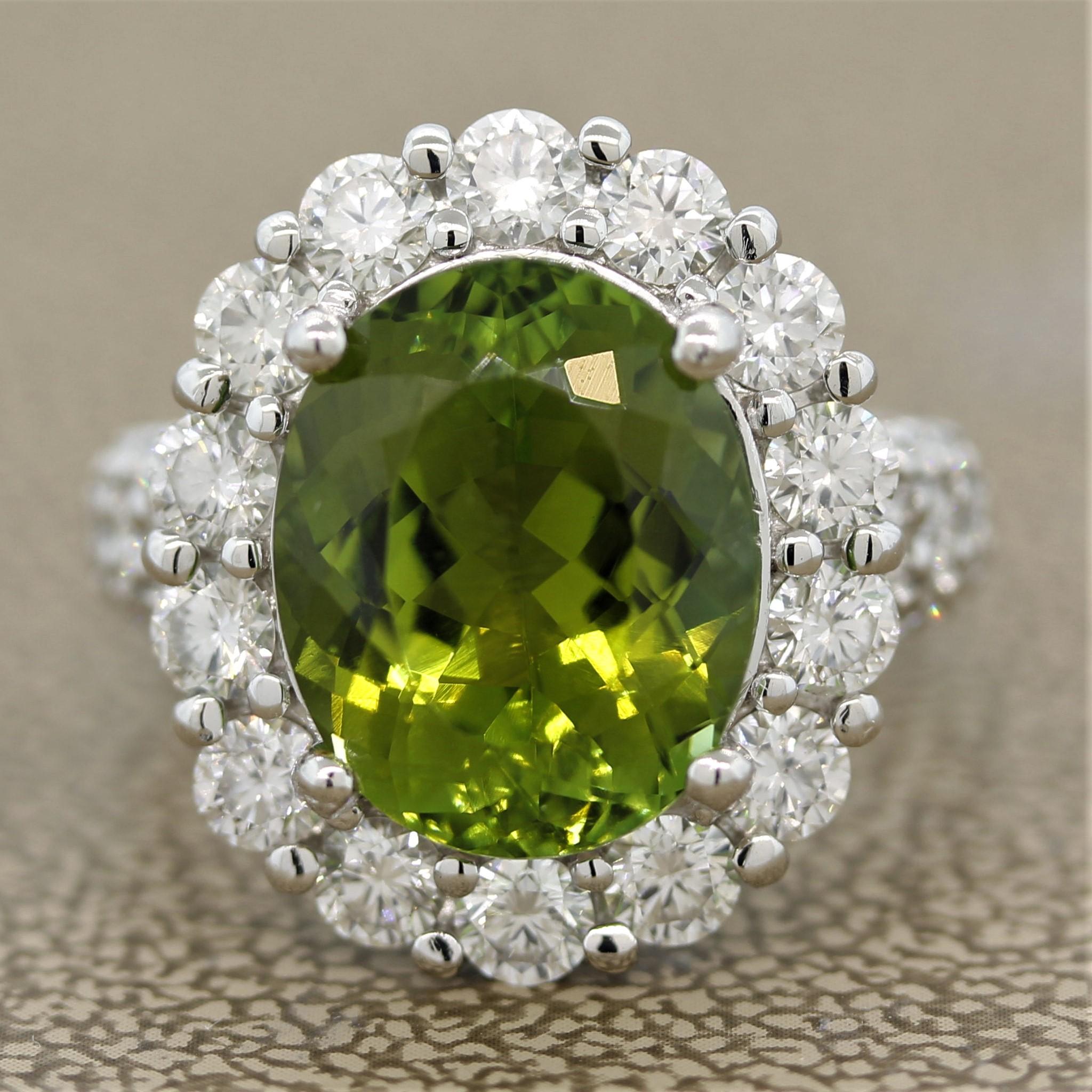 A bright and lively green tourmaline! It weighs 6.13 carats and is cut as an oval shape with a bright sharp green color. It is accented by 1.95 carats of fine round brilliant cut diamonds which halo the tourmaline and run down the sides of the ring.