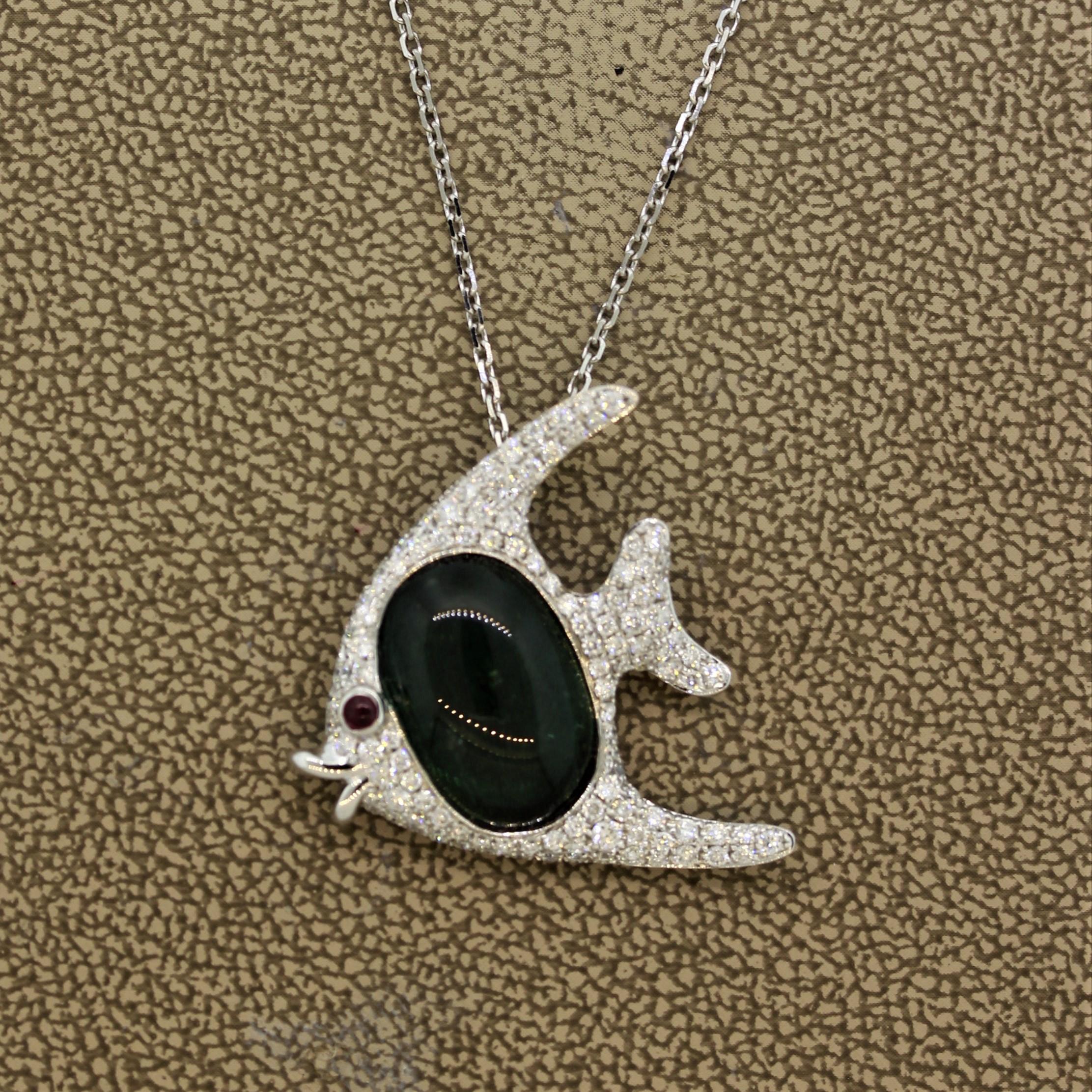 A sweet swimming fish! It features 0.85 carats of round brilliant cut diamonds set around the fish with an 8.14 carat green tourmaline set in the middle. It is finished with 1 cabochon ruby as its eye. Made in 18k white gold and ready to swim