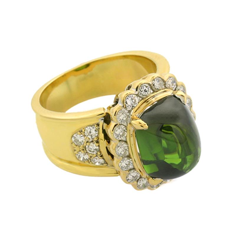 Cocktail ring with a green tourmaline (verdelite) approx. 5,60 carat, color: deep moss green, transparent quality, in cushion cut, in four-prong setting. The frame and the shoulders are set with 28 brilliant-cut diamonds approx. 0,75 carat in total,
