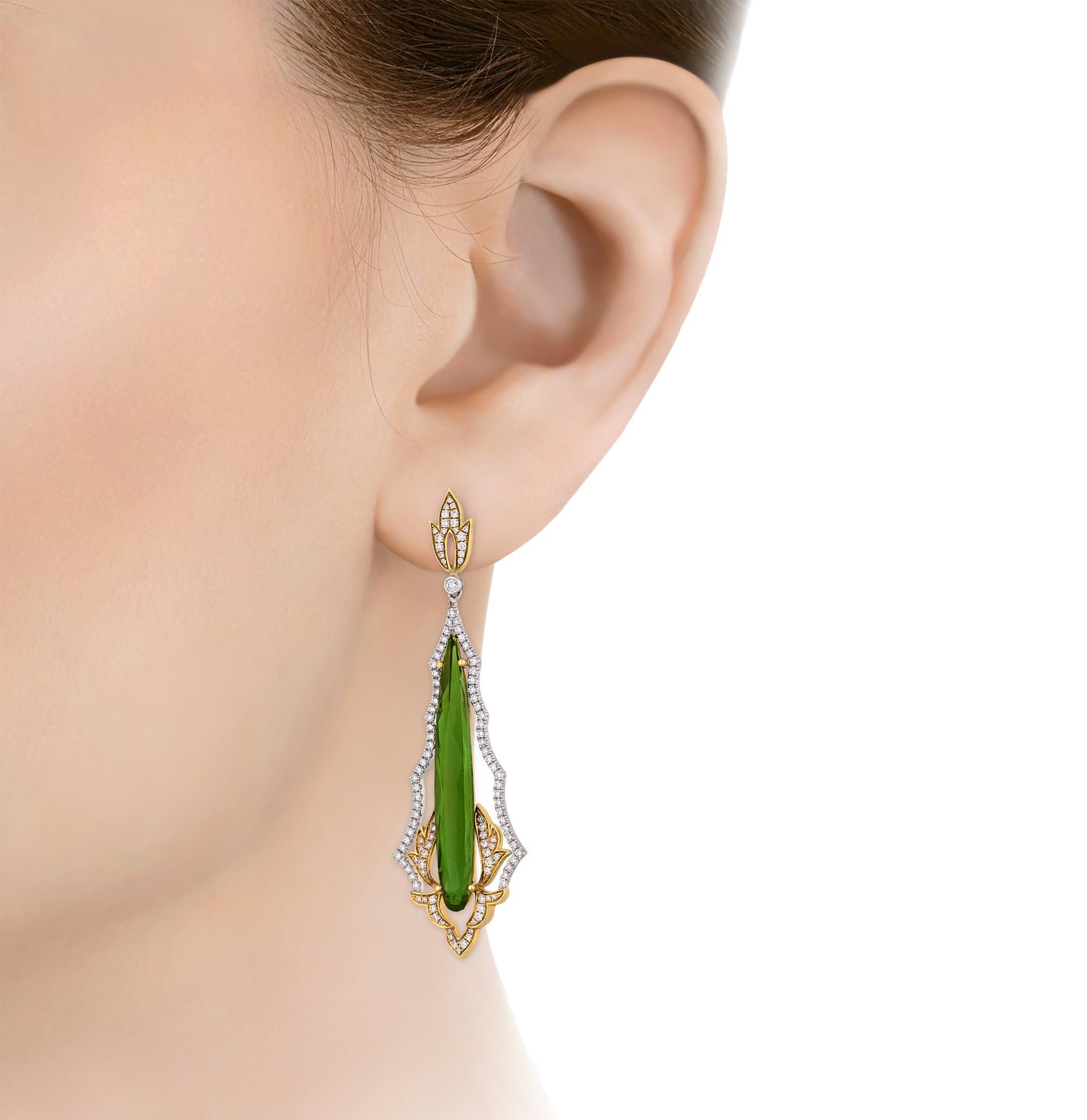 Elegant and vibrant, these drop earrings present a striking pair of teardrop cut green tourmalines totaling 14.16 carats. Their vivid verdant hue is enhanced by an undulating border of 1.84 carats of sparkling white diamonds that dances around the