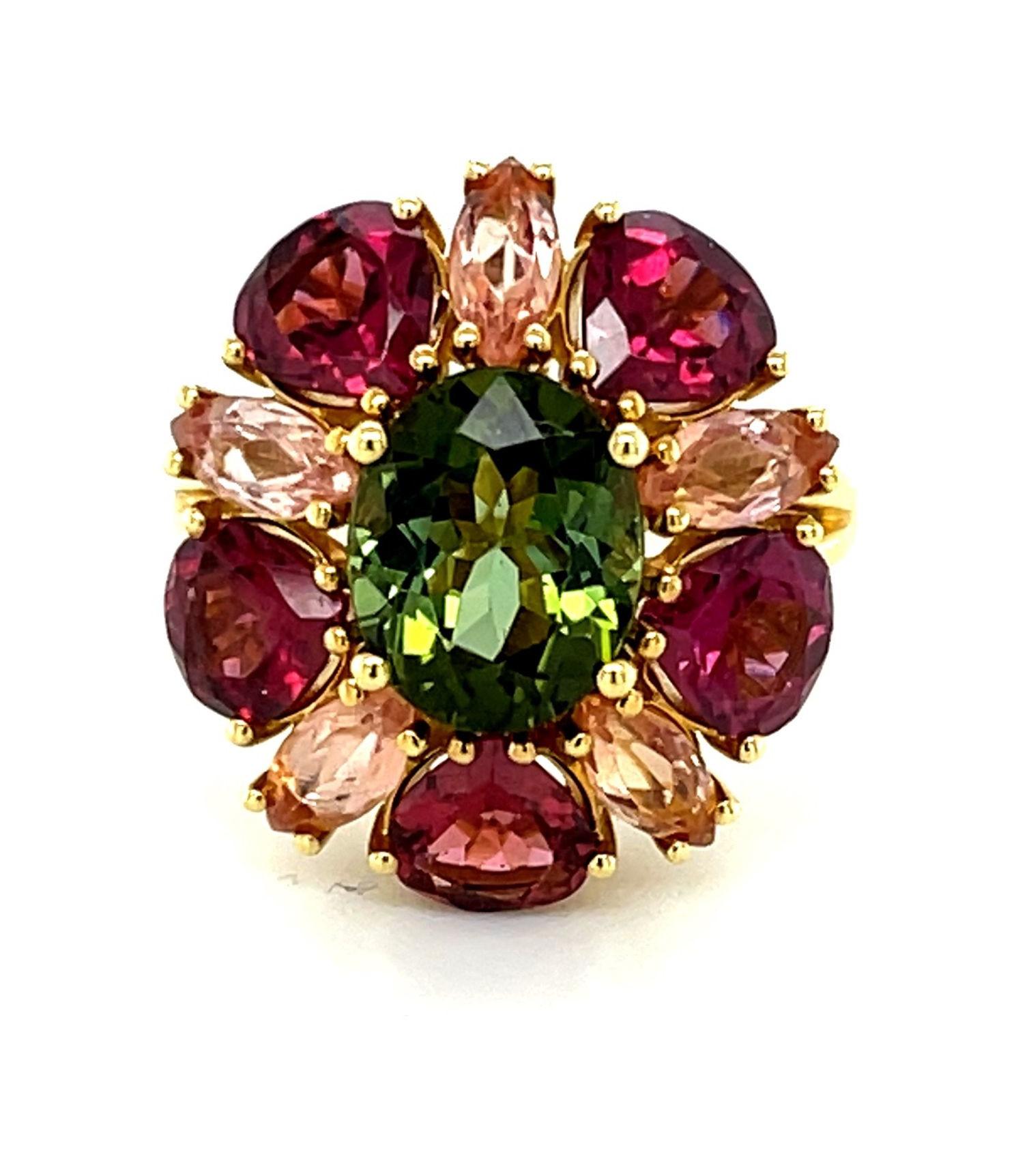 This happy ring designed with a kaleidoscope of gems is sure to make you smile! A vivid green tourmaline oval is encircled by rounded pear-shaped garnets and marquise shaped precious topazes in a unique combination of gemstone colors and shapes that