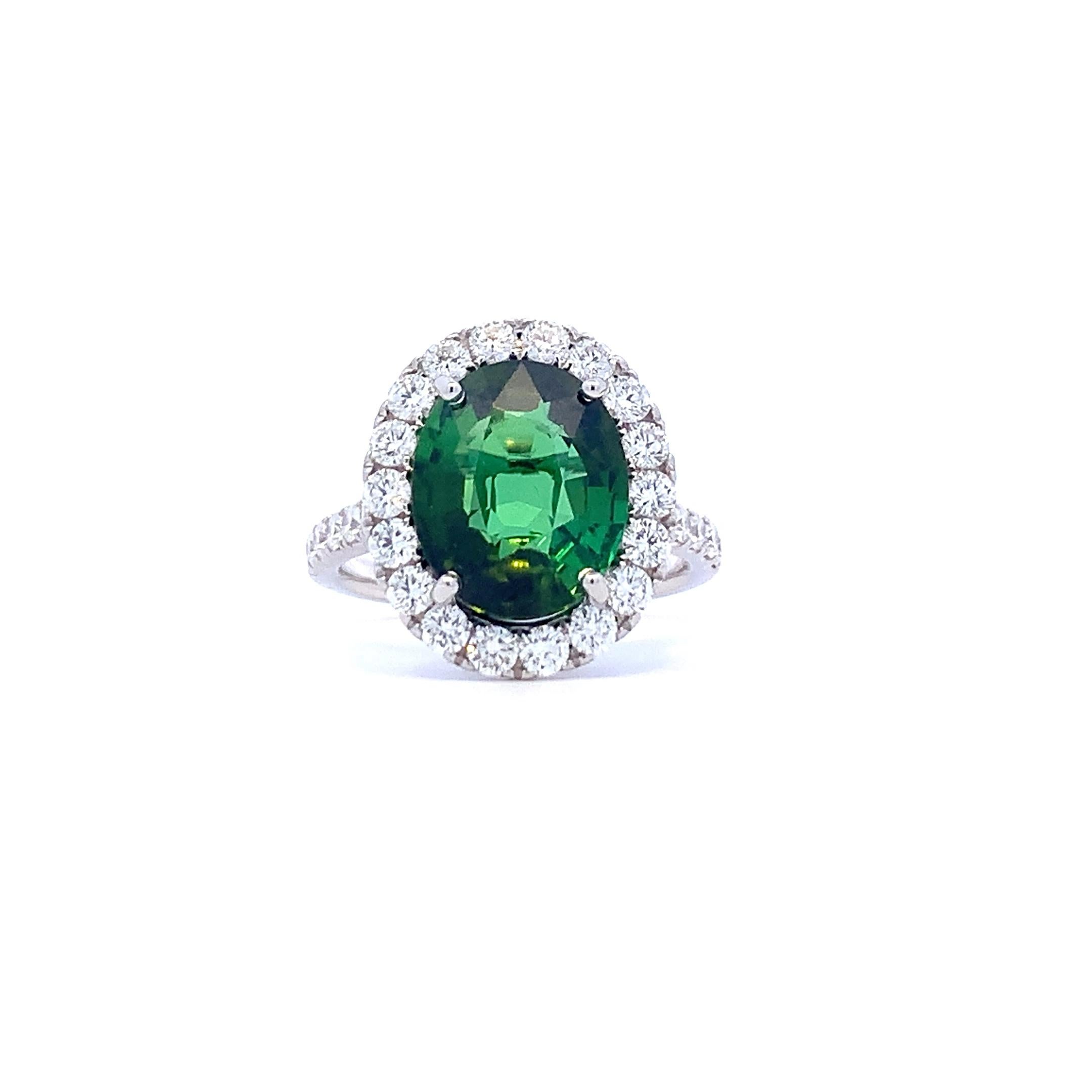 Wunderschöner Halo-Ring mit grünem Turmalin - kürzlich in unseren Bestand aufgenommen.  Der Mittelstein hat 5,13 Karat, die Diamanten 1,12 Karat, und der Ring besteht aus 18 Karat Weißgold. Kontaktieren Sie uns, wenn Sie weitere Informationen