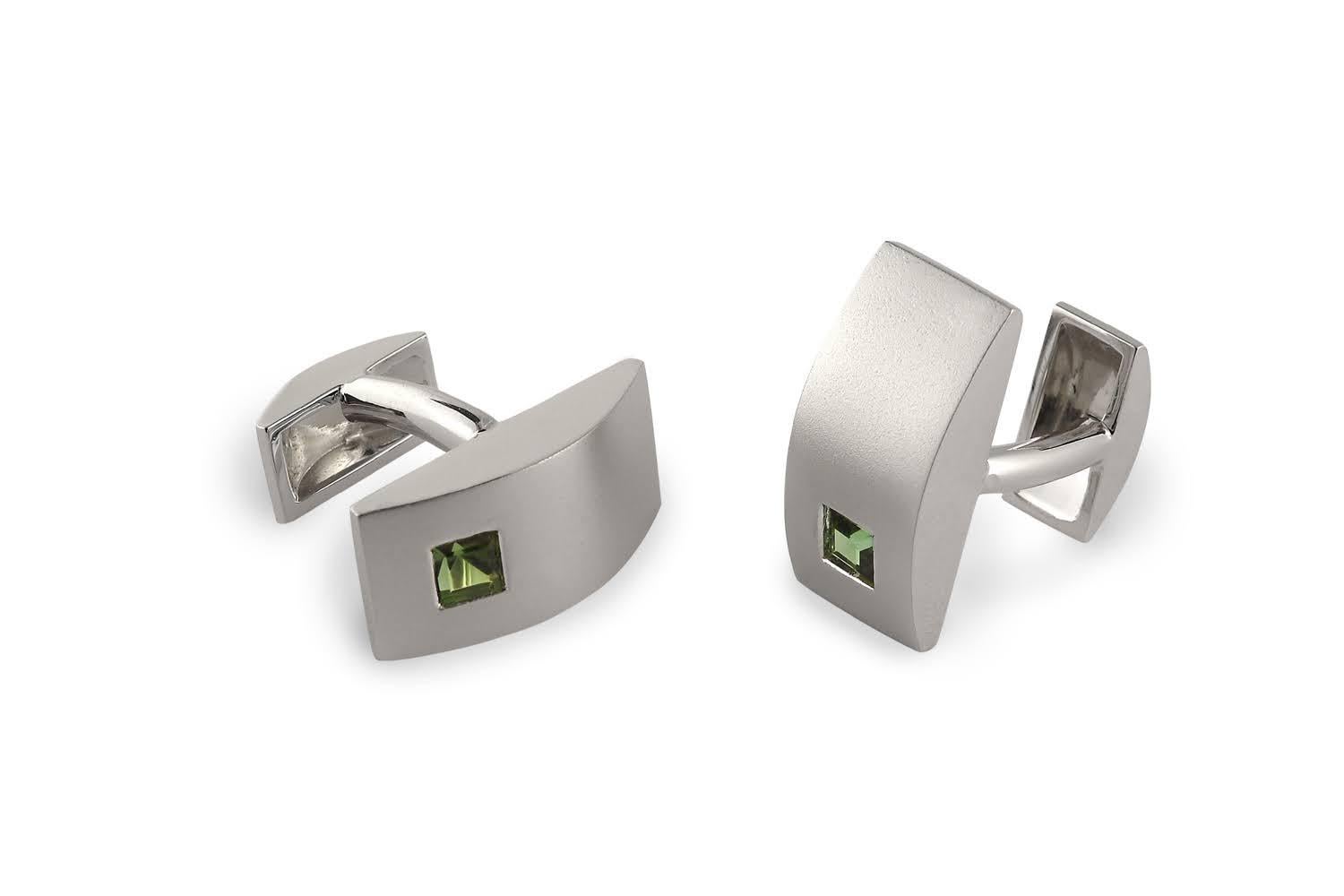 One of a kind elegance for the modern gentleman. These 18k white gold cuff links are a modern interpretation to a classic style with a slight curve and two finishes: sandblasted top and high polished sides. Each set with a 5mm princess cut green