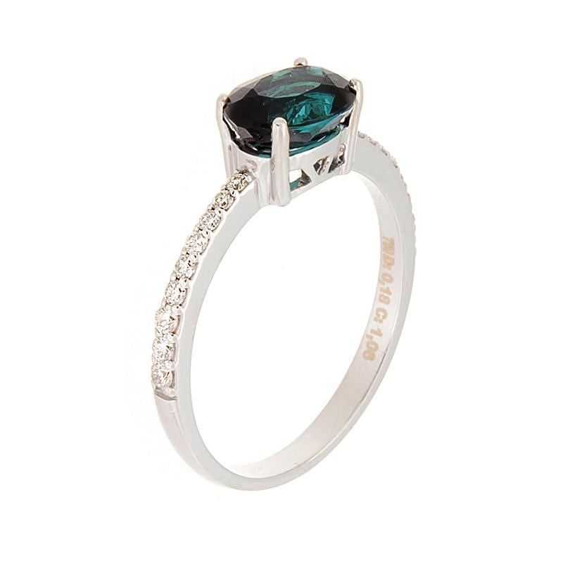 An exceptional 1.06 carat green oval cut tourmaline indicolite set uniquely horizontal. It has 0.18 carats of VS quality diamonds along the 18K white gold setting.   

Currently ring size 6.50