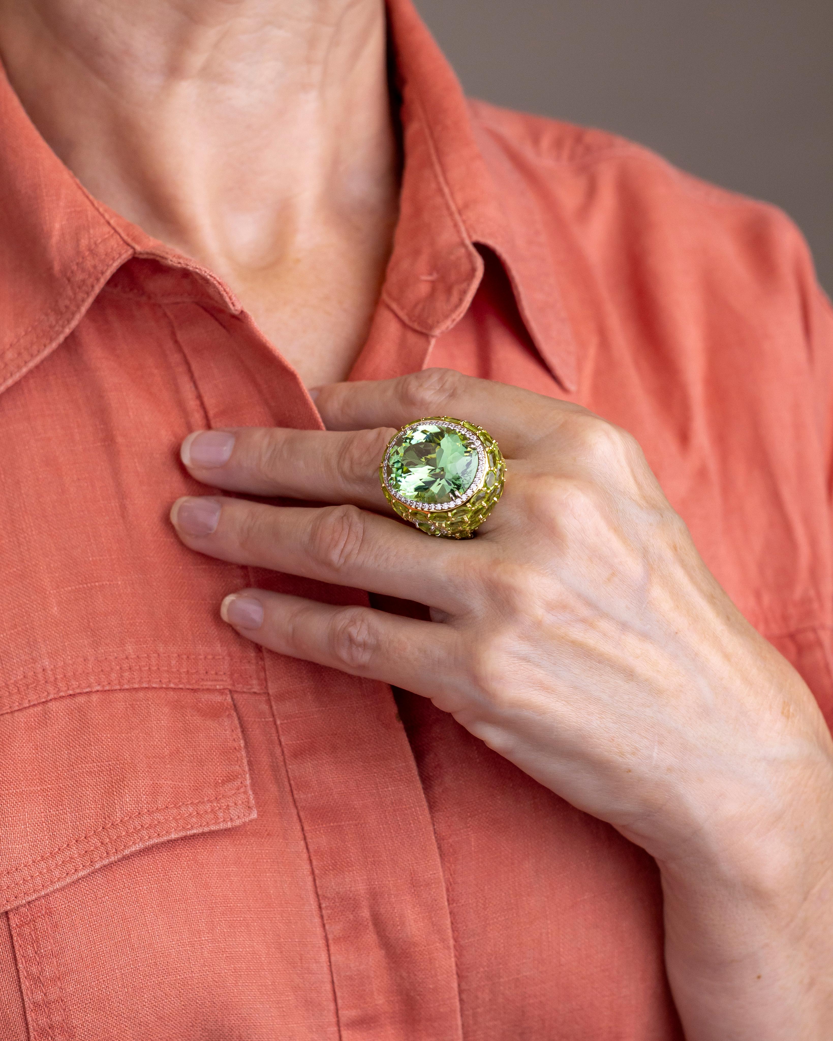 This rather spectacular cocktail ring was made by Los Angeles based jeweller 'Hubert' and is crafted from 18 karat yellow and white gold, diamonds, peridots and a large 33 carat green tourmaline. The central tourmaline has been set with four double