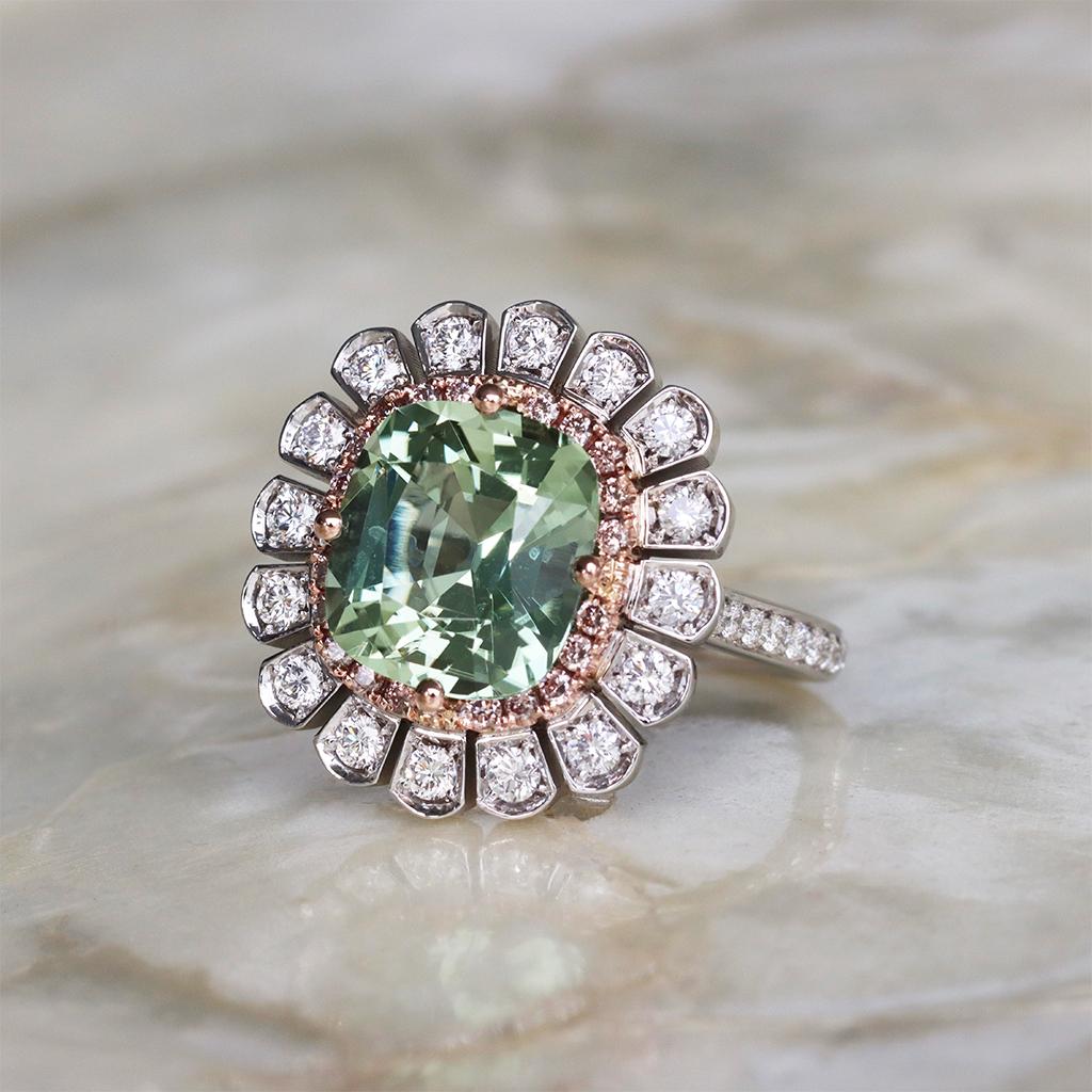 Cette bague d'entourage unique est une pièce exquise de joaillerie fine, fabriquée à la main avec un savoir-faire et un soin exceptionnels en Belgique. 

La bague est ornée d'une magnifique tourmaline vert clair, pesant un poids impressionnant de