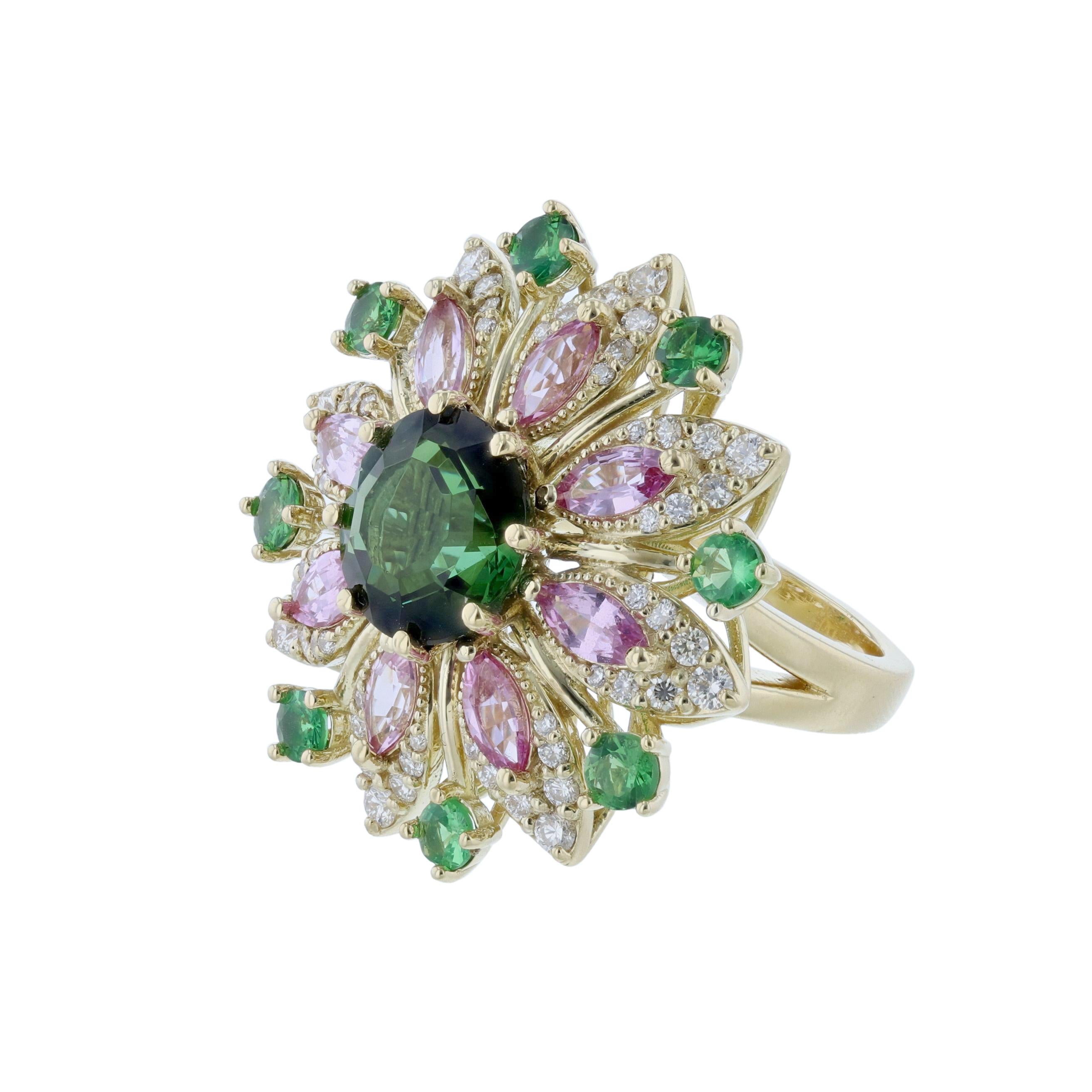 This ring is made in 14K yellow gold featuring 1 green tourmaline center stone weighing 4.15 carats. 8 marquise pink sapphires weighing 1.88 carats. Surrounded by 56 round cut diamonds weighing 0.75 carats. As well as 8 green round tsavorite accents