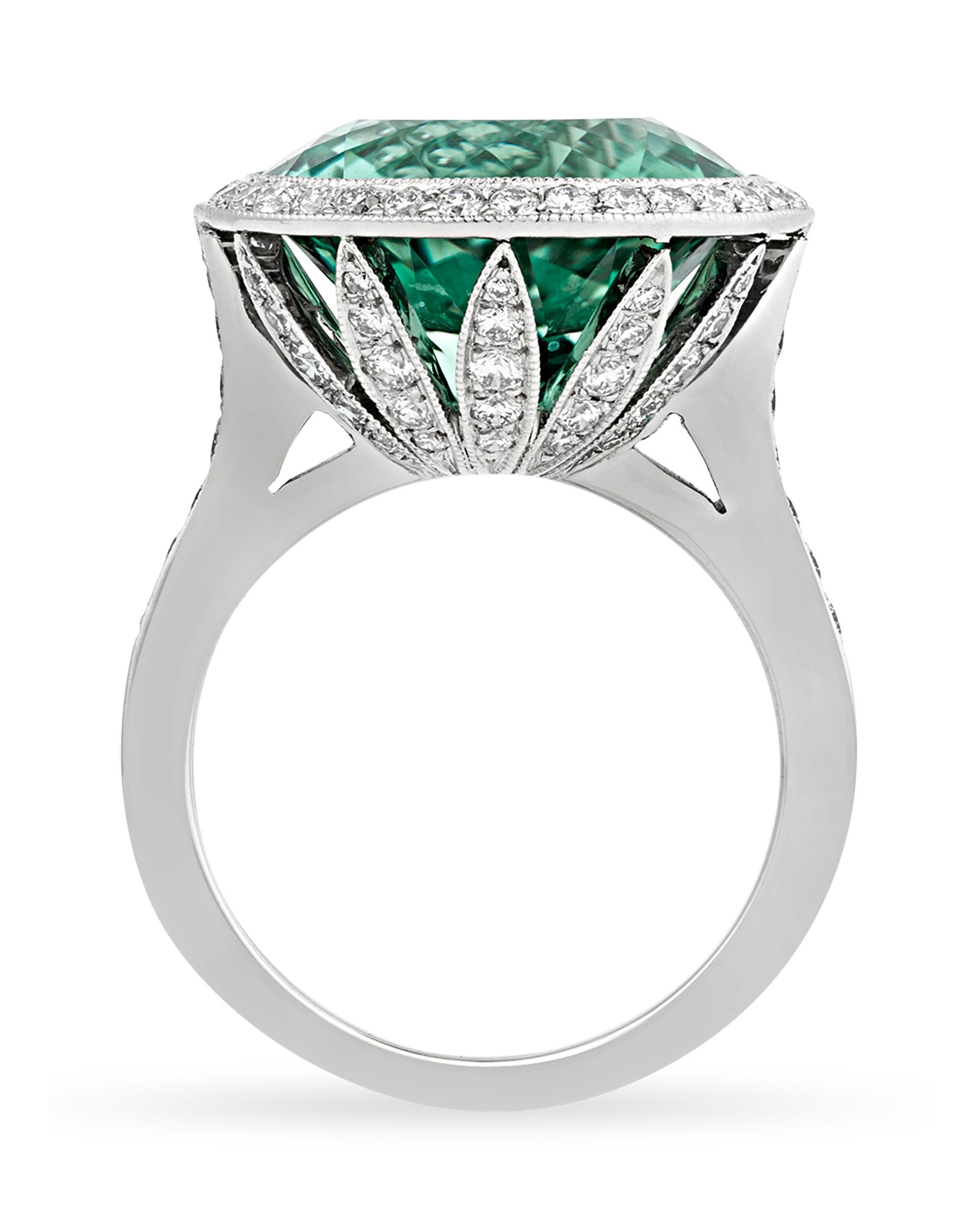 A stunning round green tourmaline weighing 8.73 carats is at the center of this classic ring by Tiffany & Co. Displaying a crisp, green hue, the gemstone is complemented by round brilliant-cut diamonds totaling 0.86 carat that display G color and