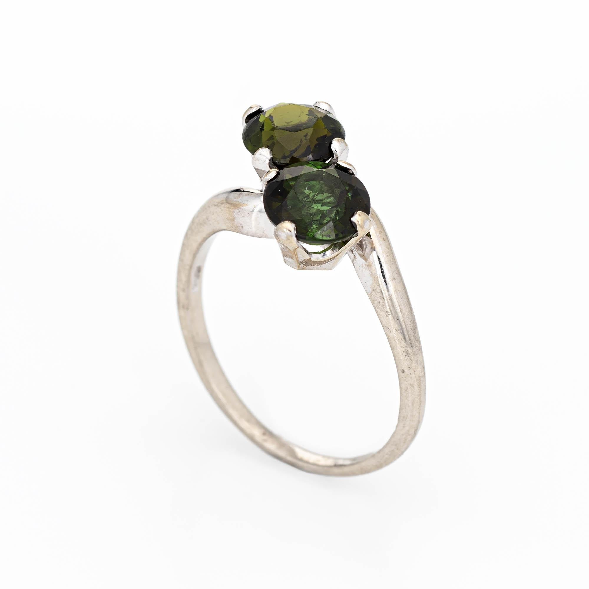Finely detailed vintage green tourmaline 'moi et toi' ring crafted in 14k white gold. 

Two estimated 1.50 carat (each) faceted round cut green tourmalines total an estimated 3 carats. The tourmalines are in excellent condition and free of cracks or