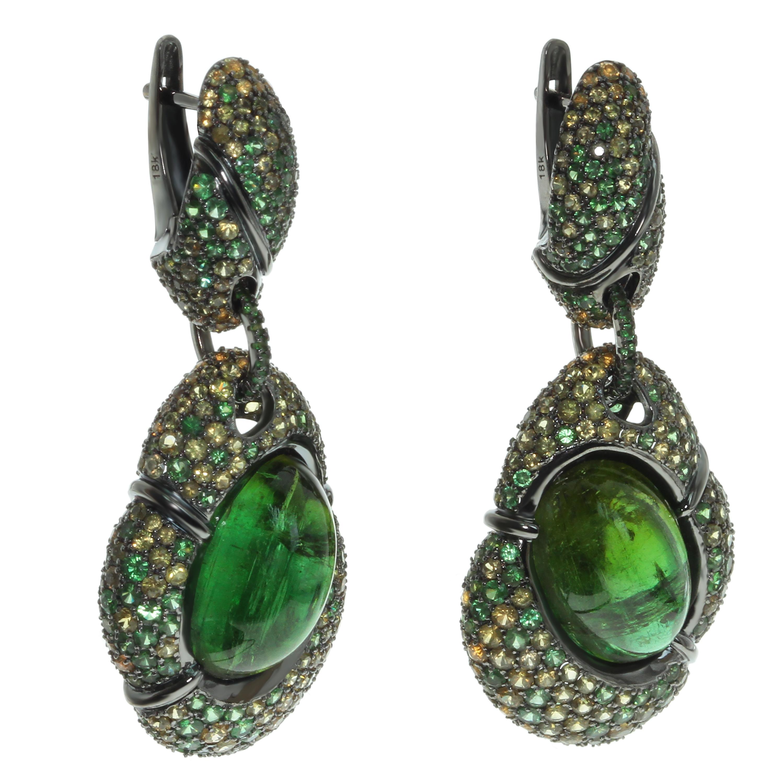 Green Tourmaline Yellow Sapphire Tsavorite 18 Karat Black Gold Earrings
Absolutely spactacular 2 Green Oval Cabochon shape Tourmalines weighing 23.50 Carat surrounded by 18K Black Gold and mix of Tsavorites and Yellow Sapphires inspires thoughts