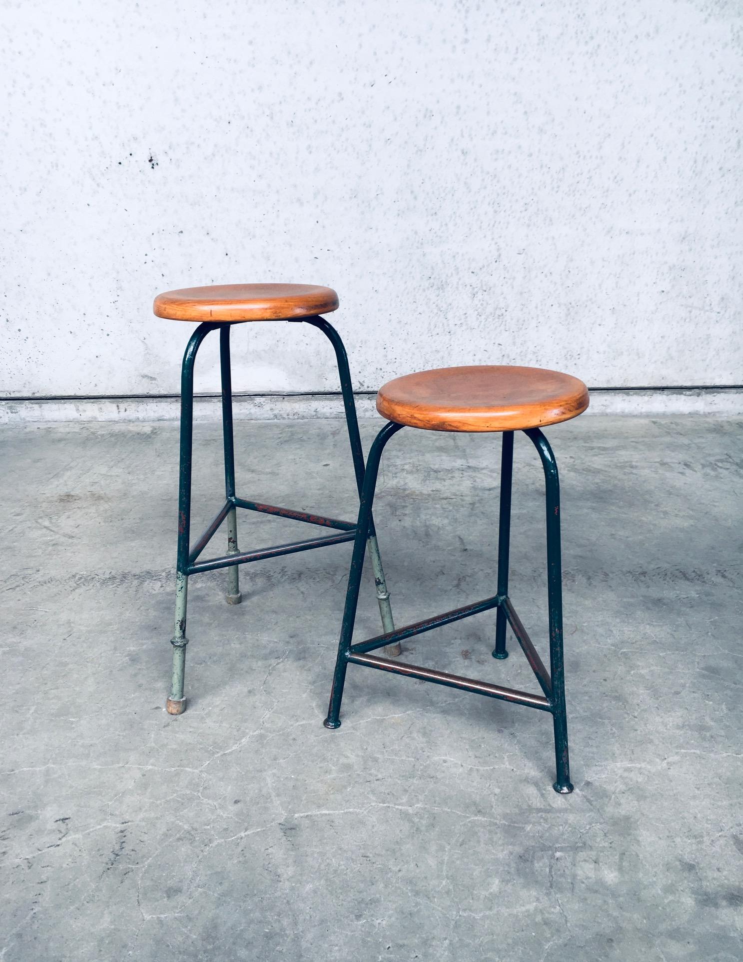 Vintage Industrial Design Dreibeinhocker Set. Hergestellt in Belgien, aus den 1950er Jahren. Dreibeiniges Gestell aus grün lackiertem Stahl mit runder Sitzfläche aus Buchenholz. Ein Hocker wurde zu einer höheren Sitzfläche umgebaut, was Sie an der