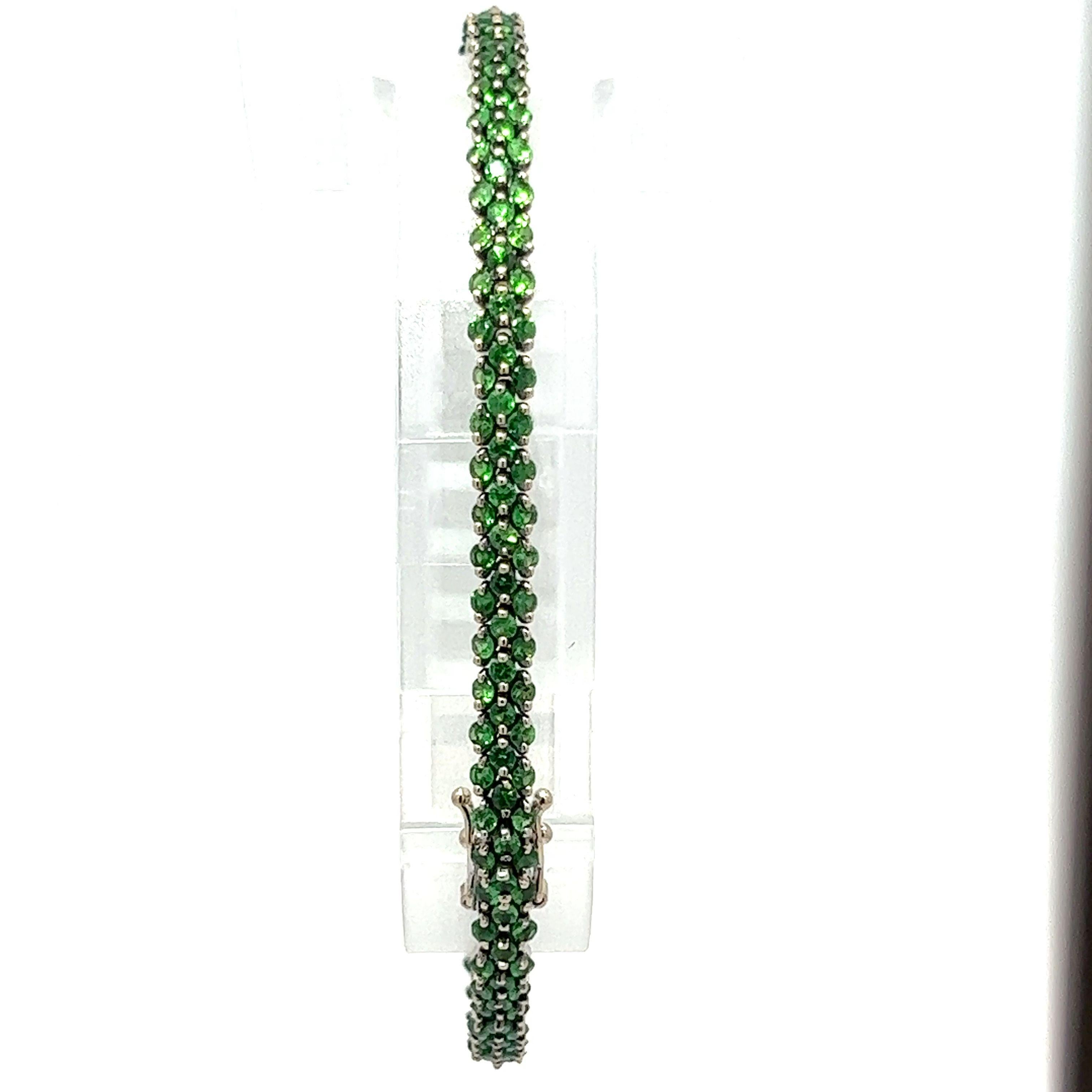 --Stone(s):--
200 Natural Genuine Tsavorite (approx.)- Round Brilliant Cut - Prong Set -  Vivid Green Color - 4 to 5ctw (approx.)

Material: Solid 18k White Gold w/ Black Rhodium
Weight: 12.19 Grams
Type: Tennis Line Link
Length: Will comfortably