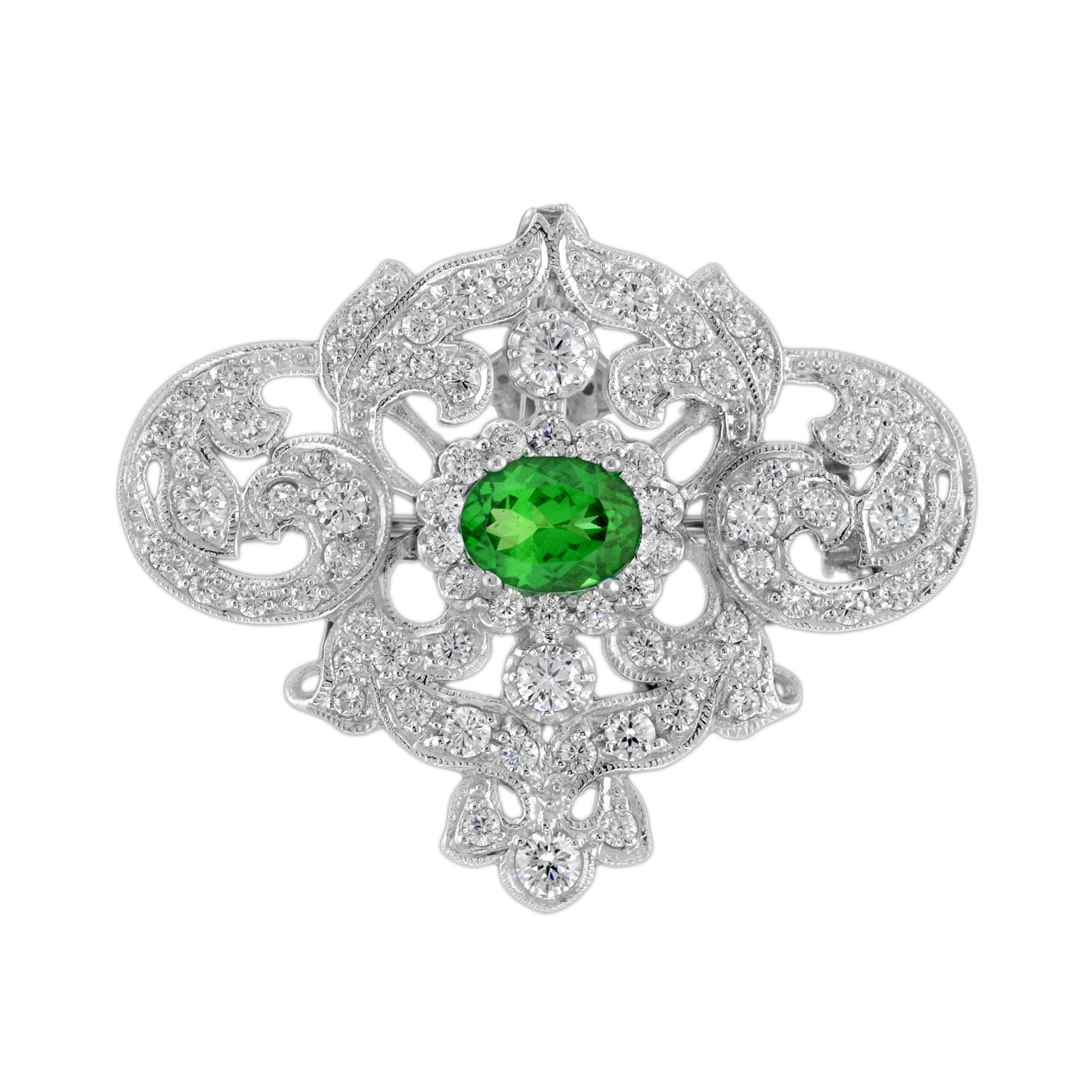 Este es un impresionante broche colgante de inspiración vintage, engastado en oro blanco, con una preciosa gema tsavorita verde de talla ovalada que mide 8 x 6 mm. El broche está engastado además con impresionantes diamantes de talla redonda de