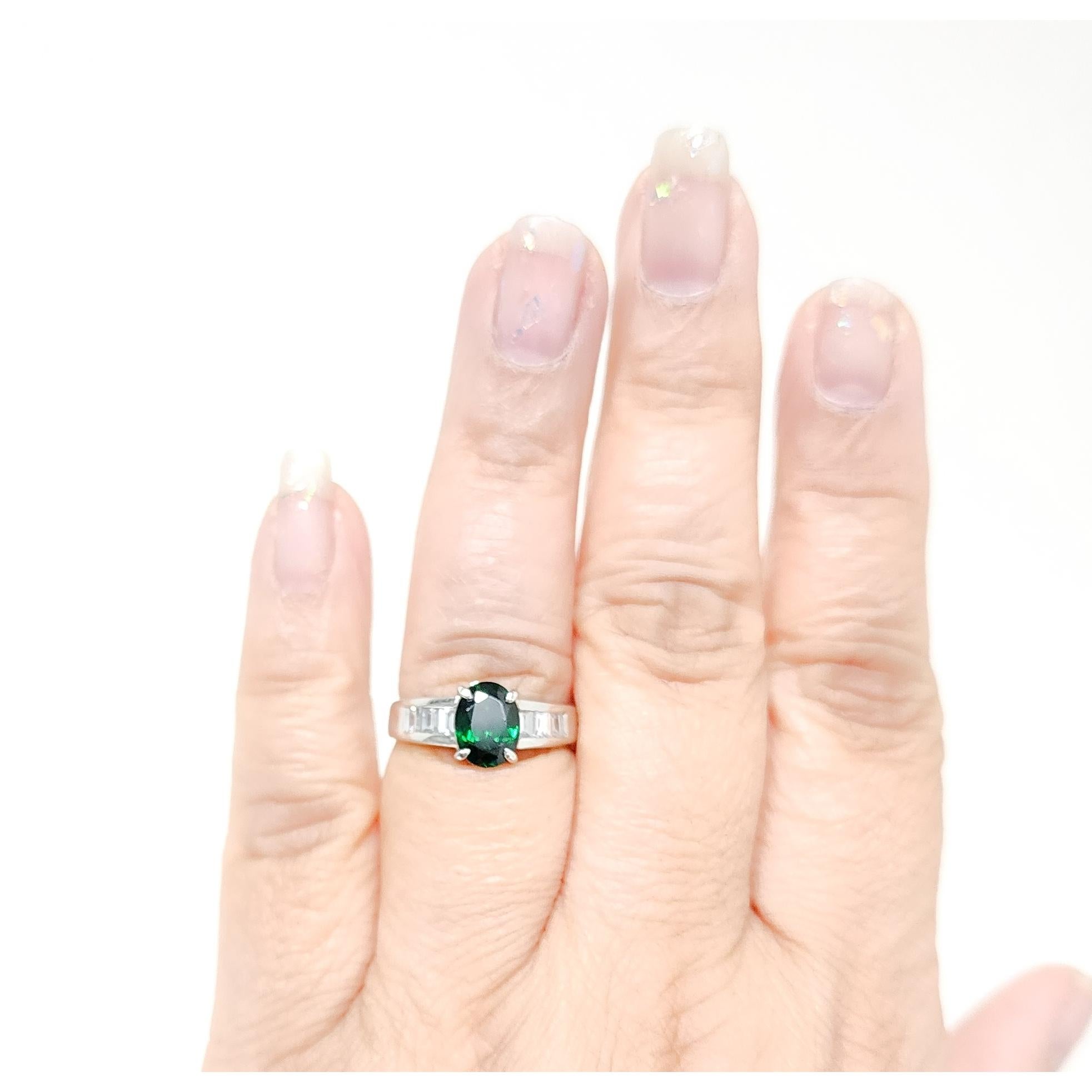 Magnifique ovale de 2,01 ct. de grenat tsavorite vert brillant avec 0,55 ct. de baguettes de diamant blanc de bonne qualité.  Fait à la main en platine.  Bague taille 7.5.