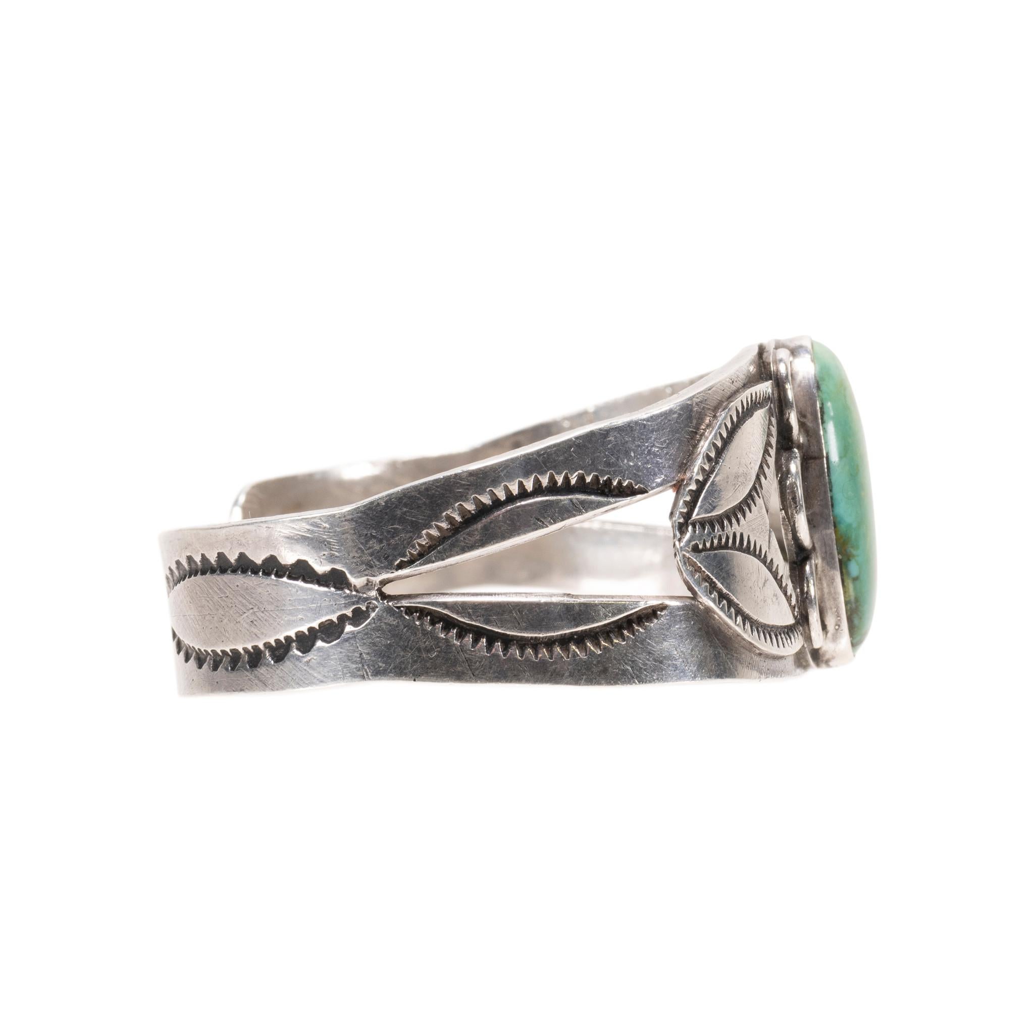 Bracciale in turchese verde e argento sterling. Pietra ovale di Damele con incastonatura a castone e bordo smerlato. La pietra è di un bel verde muschiato con matrice marrone e oro torbido. Grande profondità e colorazione. Attaccato a un polsino con