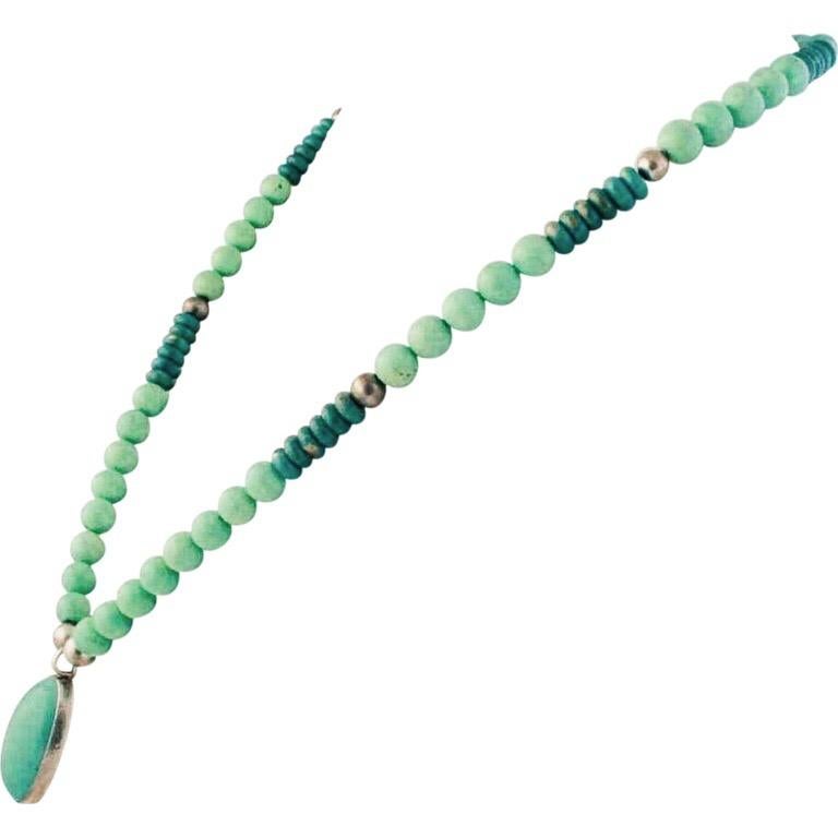 This gorgeous and stunning green turquoise oval cabochon pendant is bezel set in sterling silver and hangs from a perfectly matched green turquoise and jade beaded necklace with ten silver accent beads. This is one of my more recent designs. The