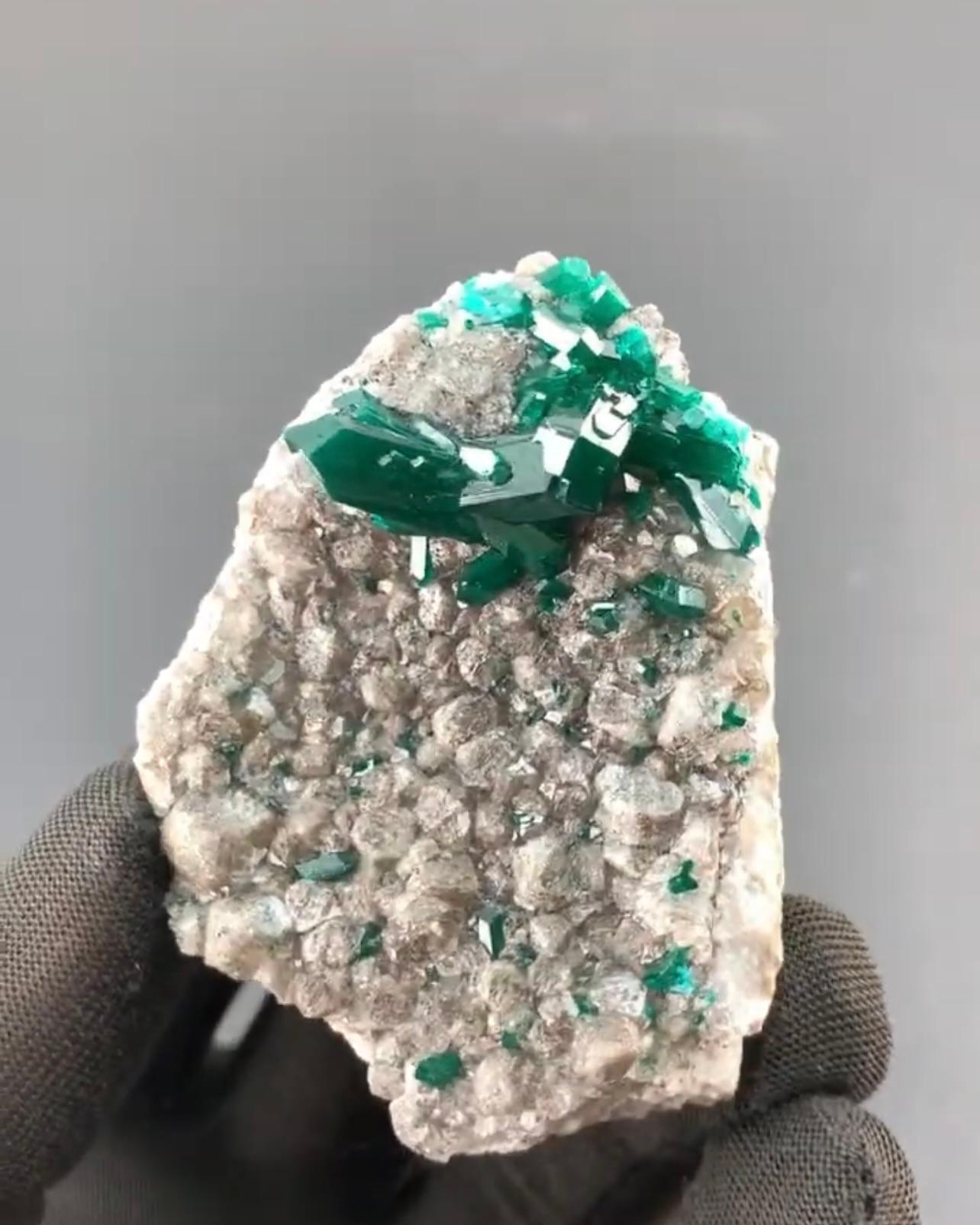 Informazioni sul prodotto:

Tipo di campione: Diottasio su calcite
Peso: 63 grammi
Dimensioni: H: 6,2 x L: 4,7 x P: 2,8 cm 
Origine: Mindouli, Dipartimento di Pool, Repubblica del Congo
Trattamento: Nessuno

Descrizione:

Questo splendido esemplare