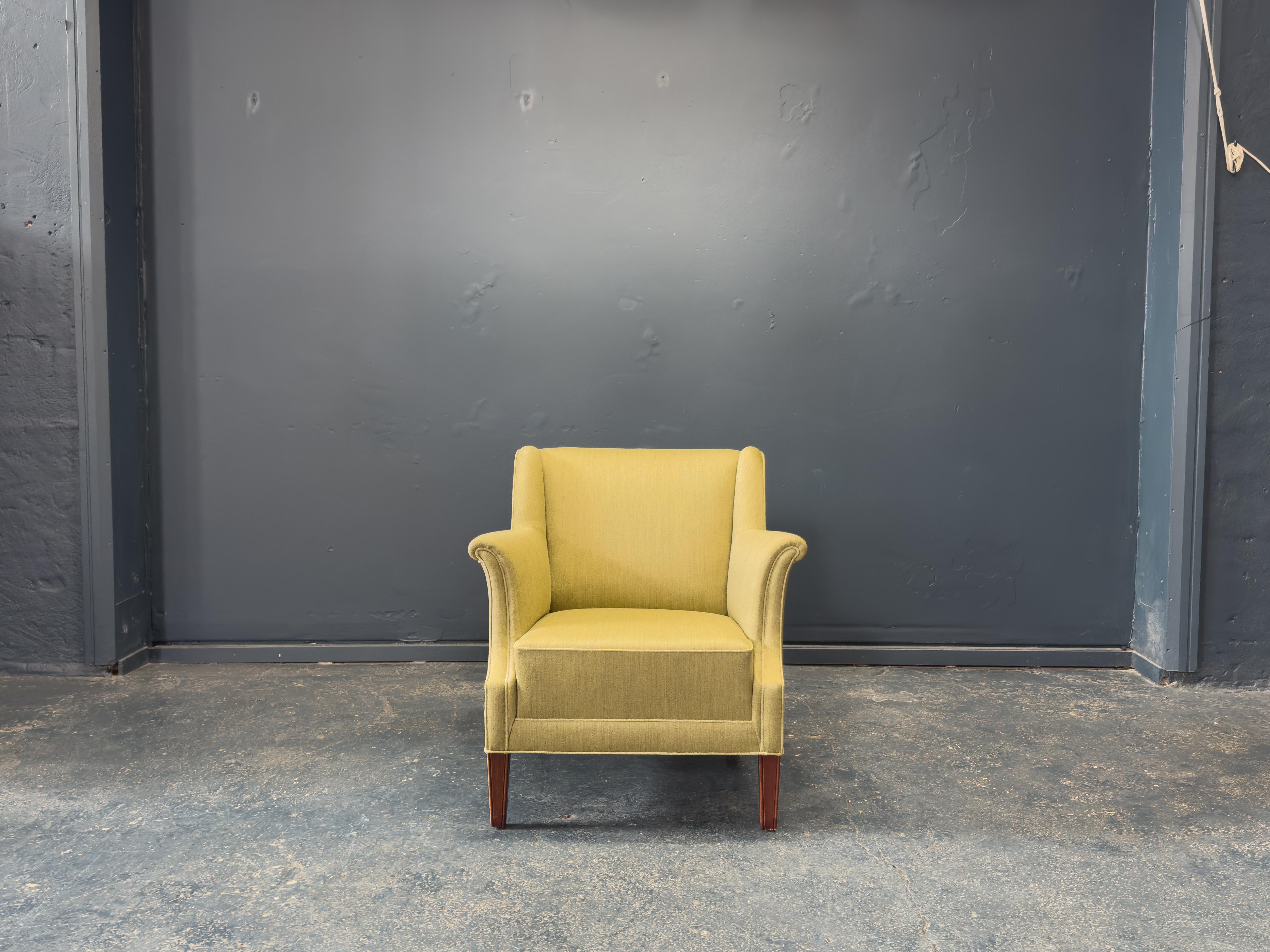 Ce fauteuil rembourré dégage une sophistication classique avec sa silhouette raffinée et sa fabrication exceptionnelle. La chaise est dotée d'accoudoirs légèrement évasés qui s'incurvent gracieusement vers l'extérieur, ce qui lui confère un profil